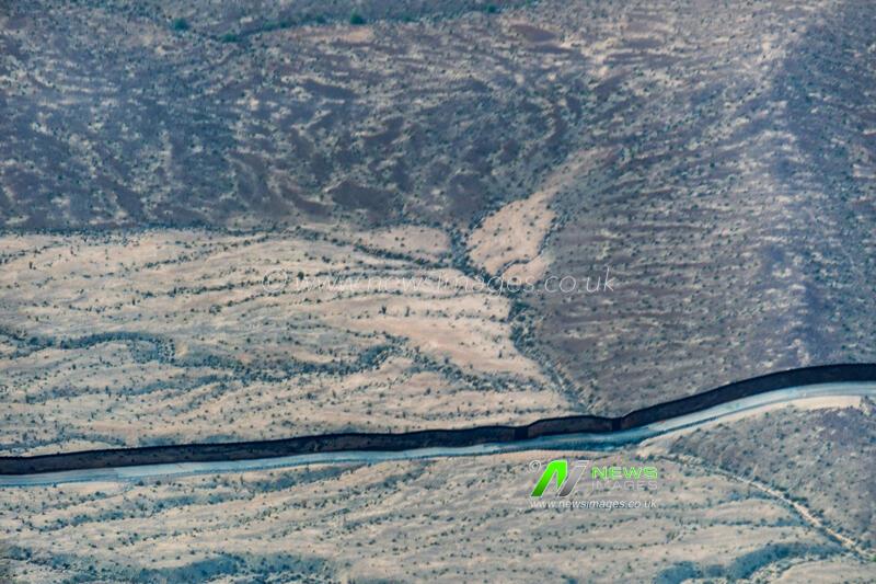 Aerial view of Mexican border wall looking south in the Imperial Valley's Colorado Desert shared with Baja California.