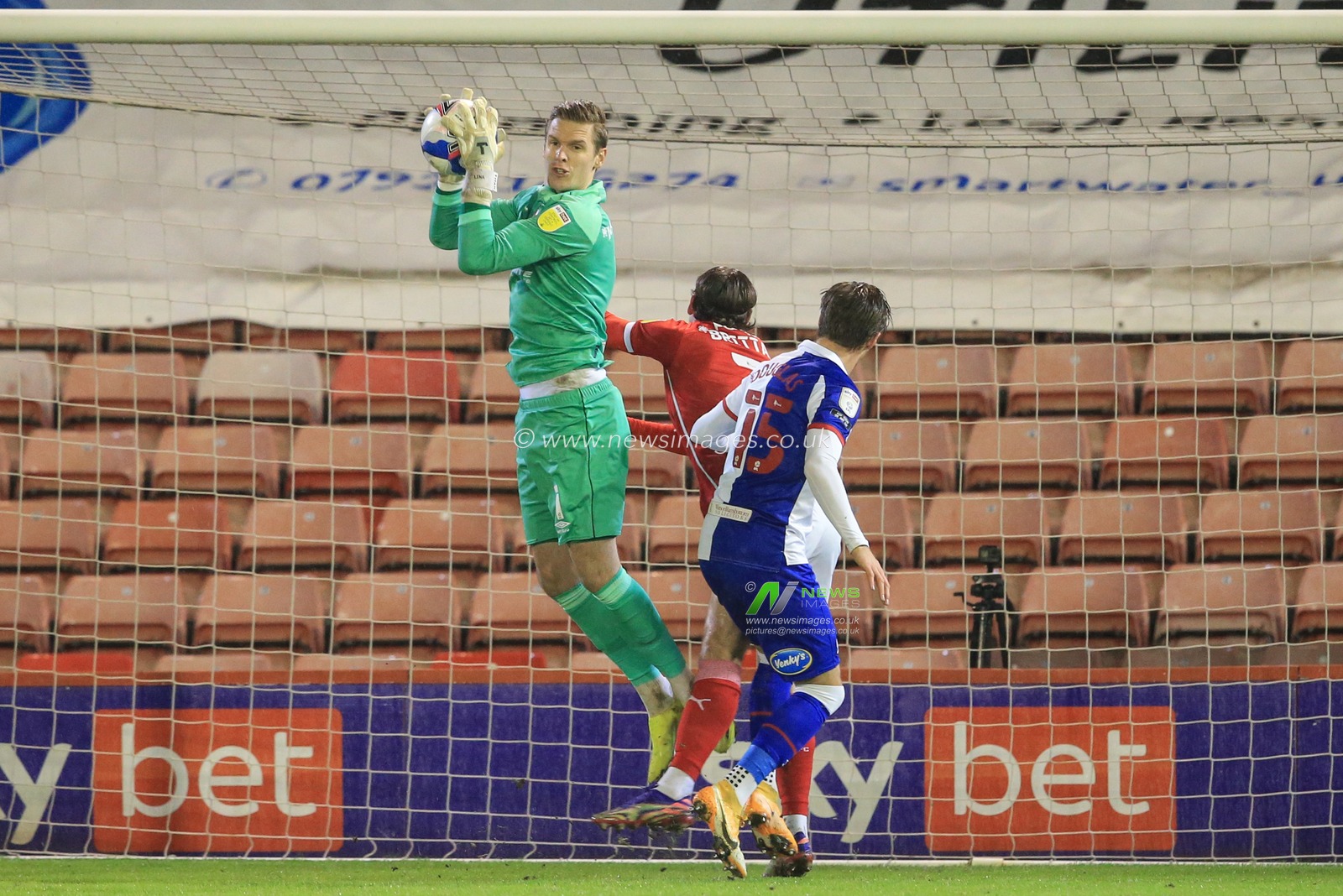 Thomas Kaminski #1 of Blackburn Rovers makes a save as Callum Brittain #7 of Barnsley pressures