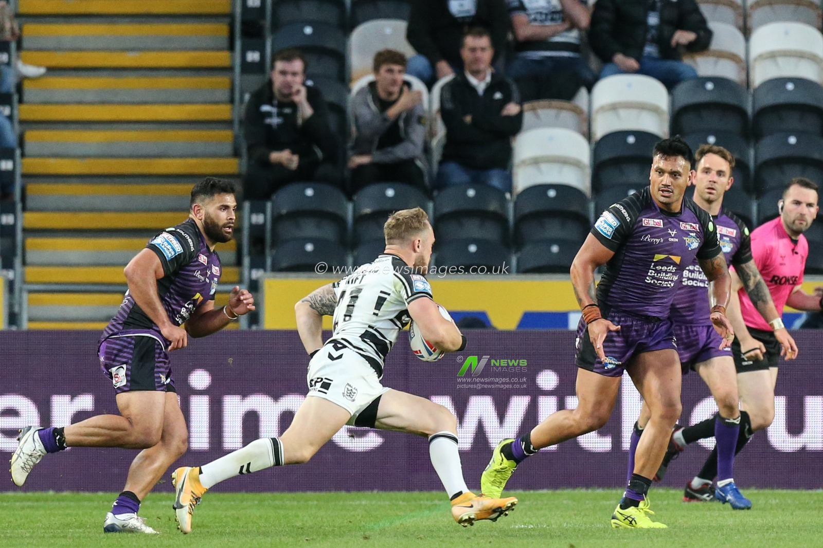 Adam Swift (21) of Hull FC runs at the Leeds defence