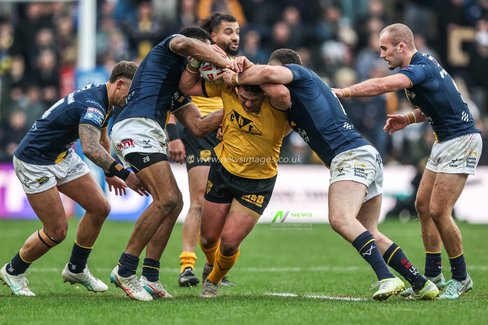 George Lawler of Castleford Tigers is tackled by Tom Holroyd of Leeds Rhinos and Cameron Smith of Leeds Rhinos during the Betfred Super League round 4 match Leeds Rhinos vs Castleford Tigers at AMT Headingley Stadium, Leeds, United Kingdom on 08 March 2026

(Photo by Alfie Cosgrove/News Images)