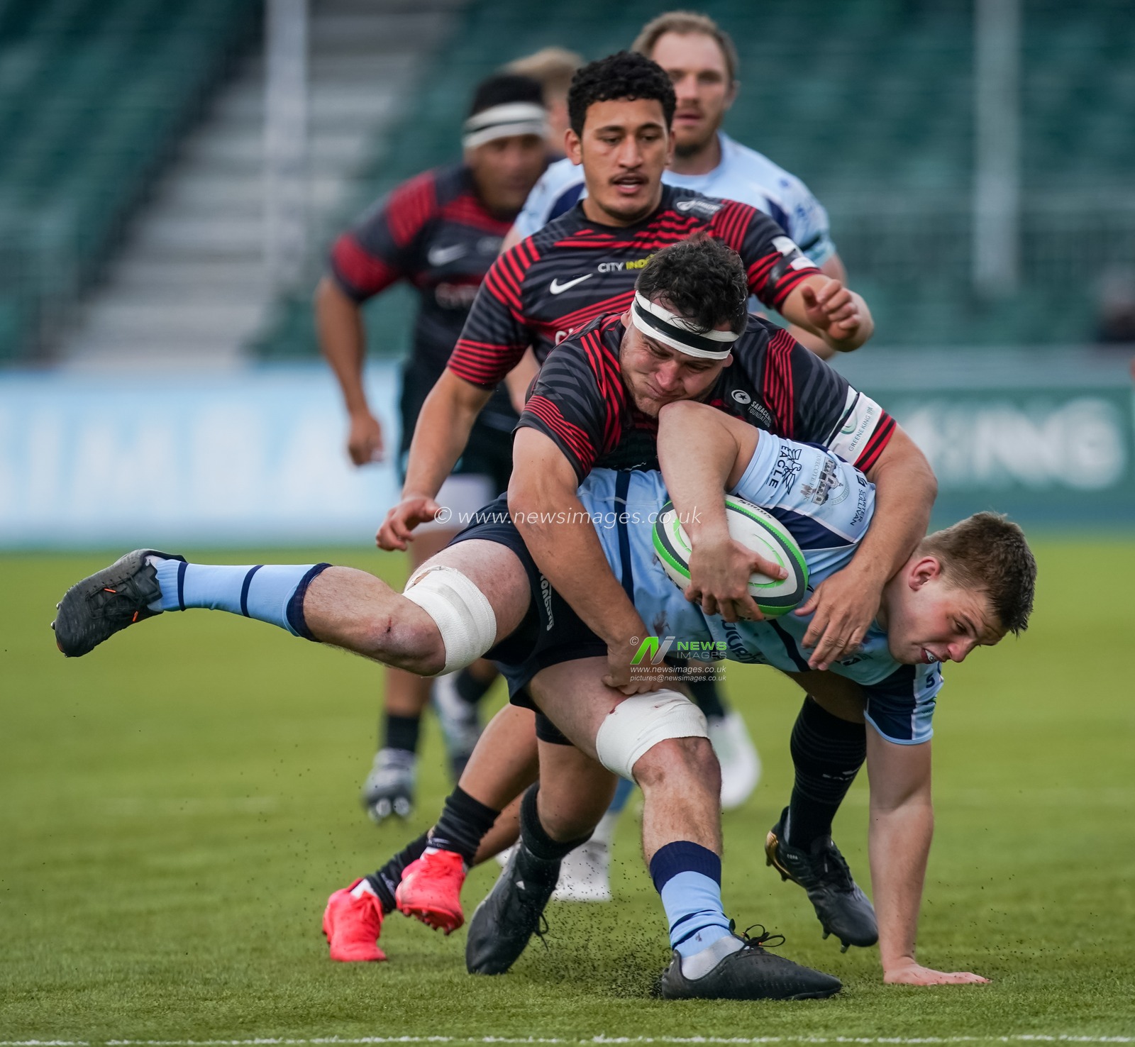 Jamie George #2 of Saracens tackles  Ollie Newman #6 of Bedford Blues
