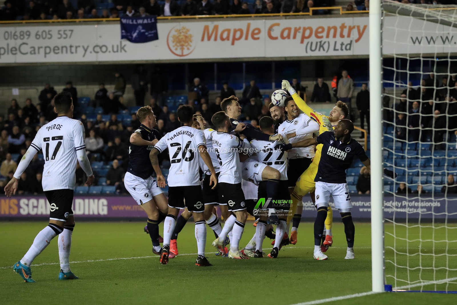 Players tussle for a cross coming into the box as Andy Fisher #33 of Swansea City tries to punch clear.