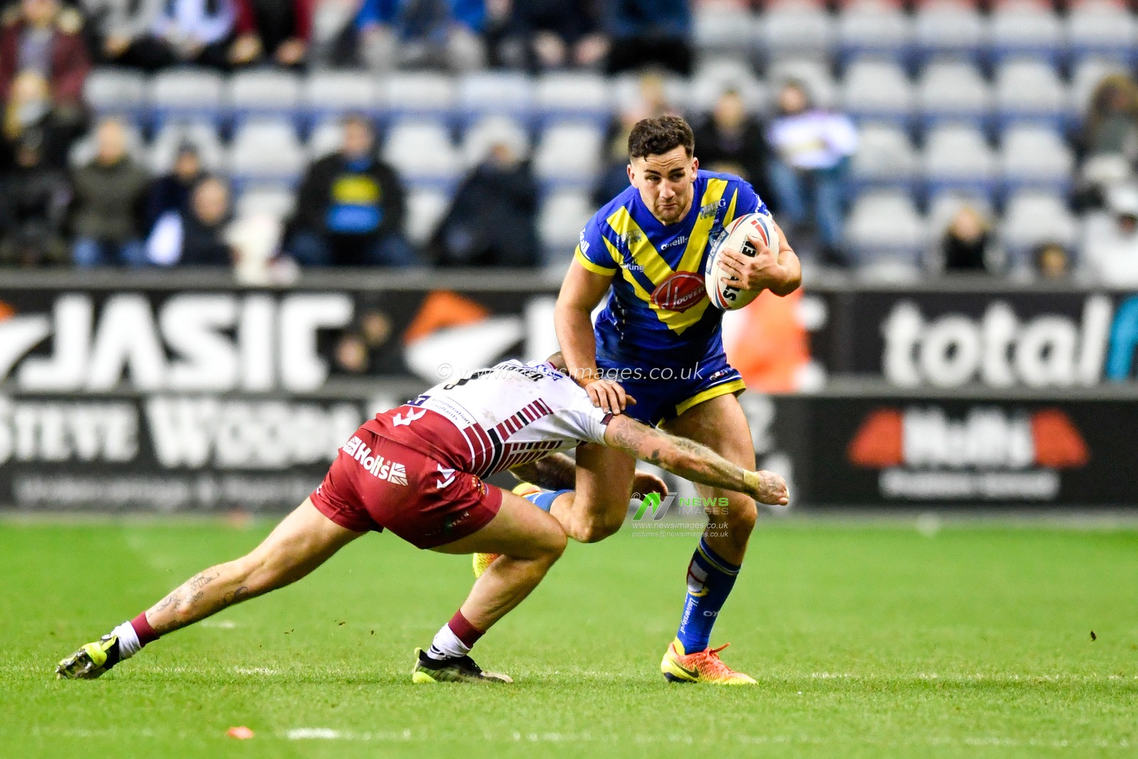 30th January 2020, DW Stadium, Wigan, England; Betfred Super League, Wigan Warriors v Warrington Wolves : Toby King (4) of Warrington Wolves is tackled by Zak Hardaker (1) of Wigan Warriors