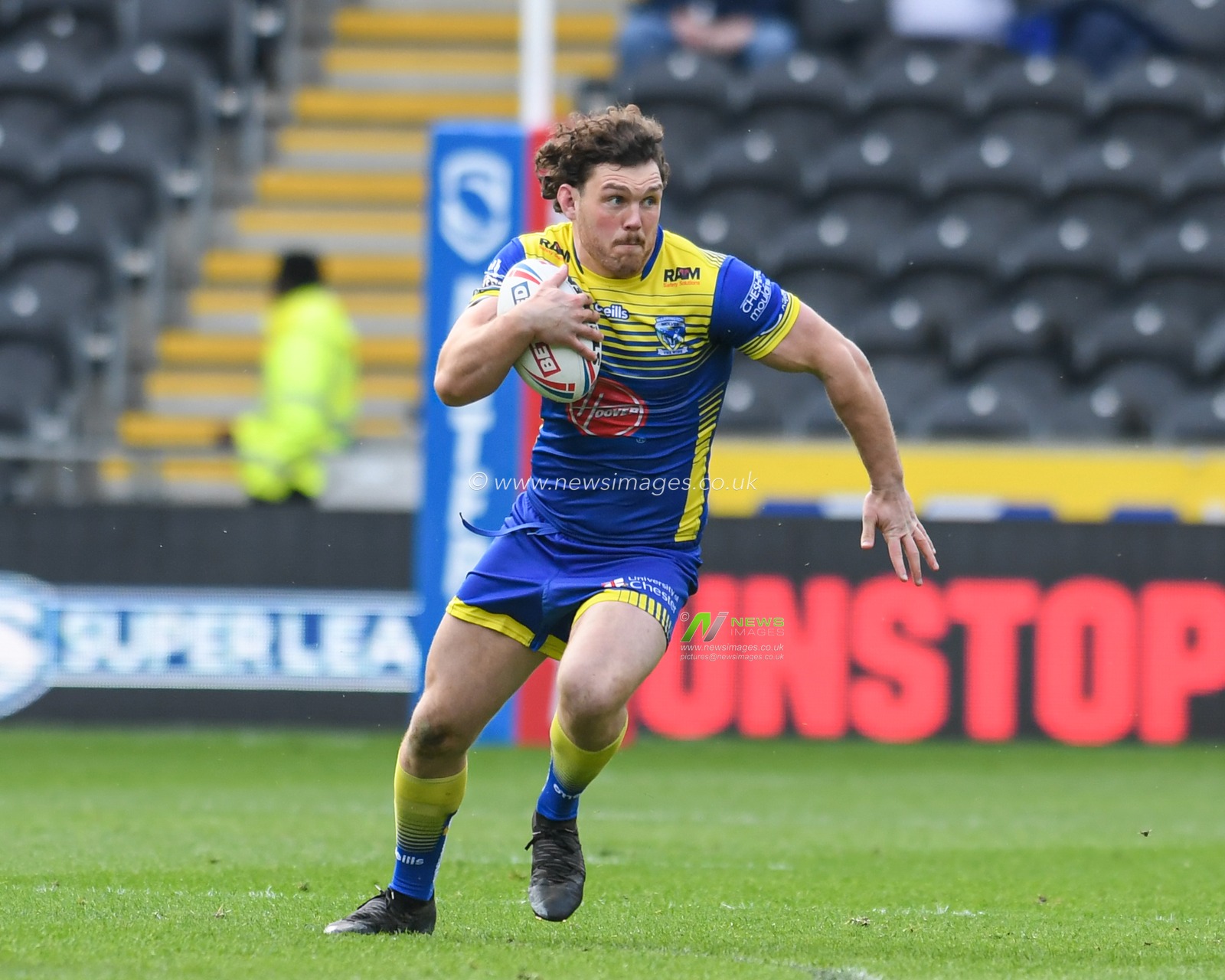 Rob Mulhern #19 of Warrington Wolves runs forward with the ball