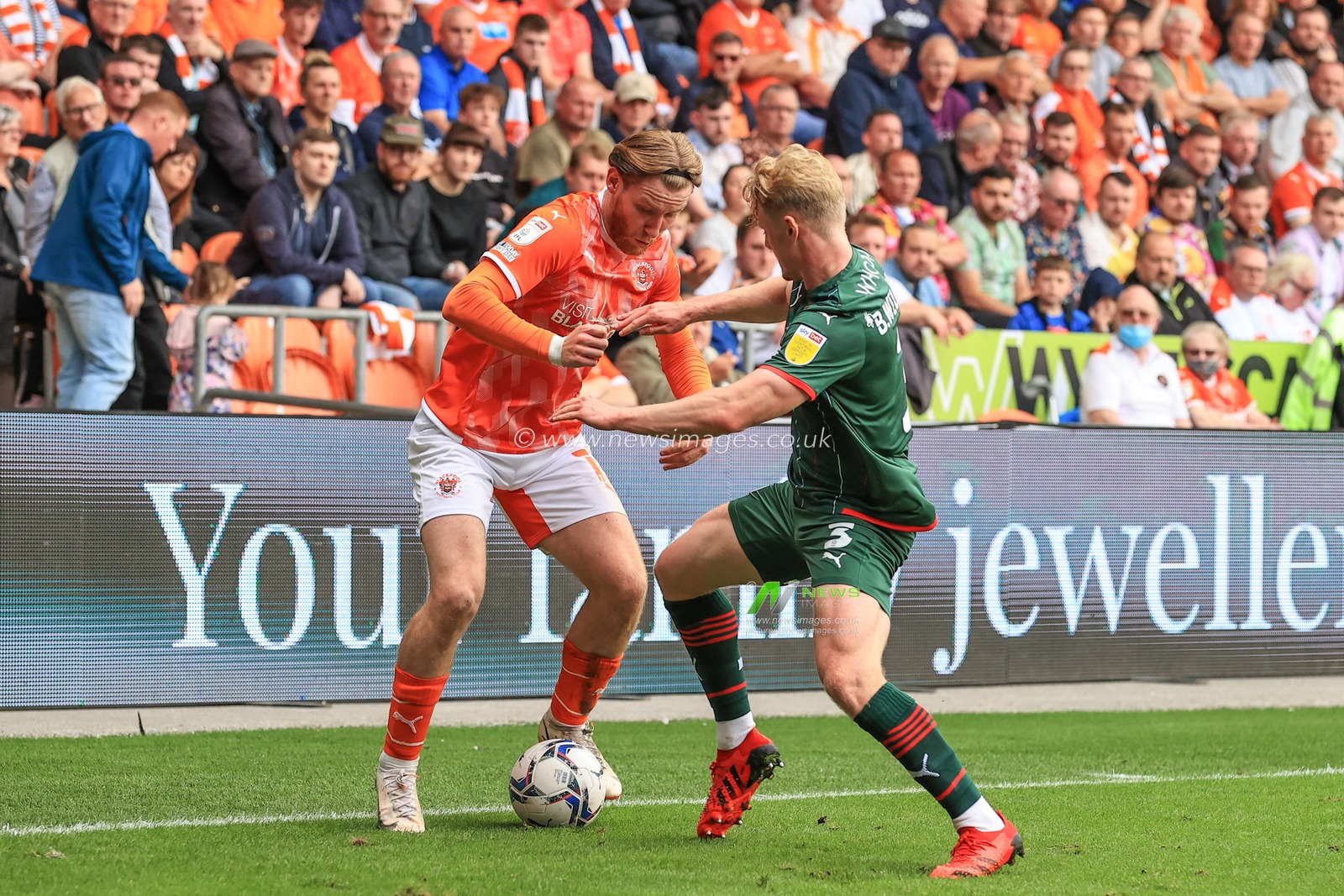 Josh Bowler #11 of Blackpool holds the ball as Ben Williams #3 of Barnsley pressures