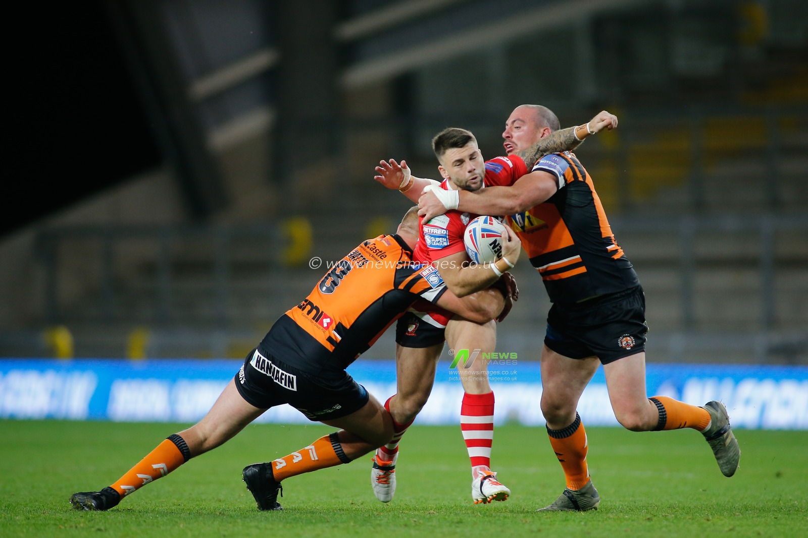 Andy Ackers (30) of Salford Red Devils tackled by Liam Watts (8) and Grant Millington (10) of Castleford Tigers.