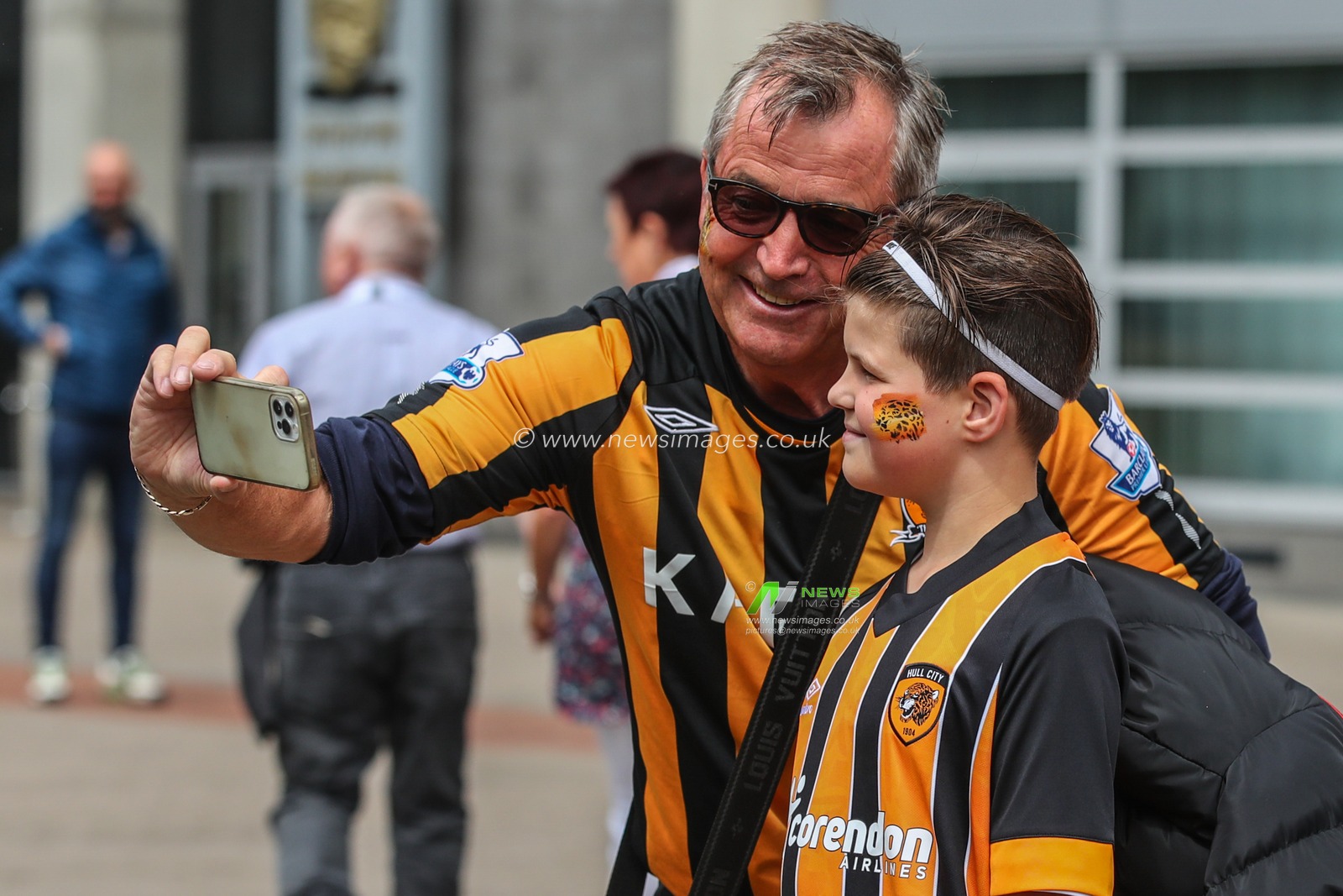 Hull City fans take a selfie after having their face paint completed