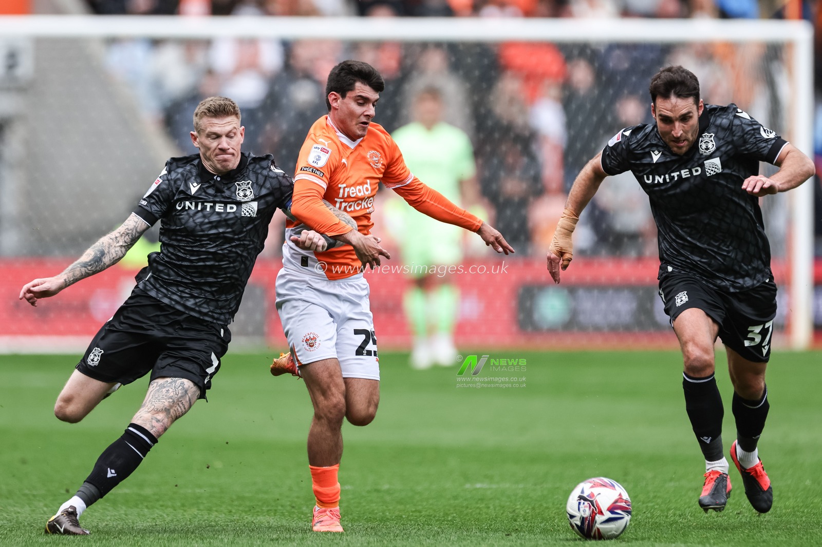 Rob Apter of Blackpool breaks with the ball and escapes the clutches of James McClean and Matthew James of Wrexham during the Sky Bet League 1 match Blackpool vs Wrexham at Bloomfield Road, Blackpool, United Kingdom, 21st April 2025

(Photo by Mark Cosgrove/News Images)