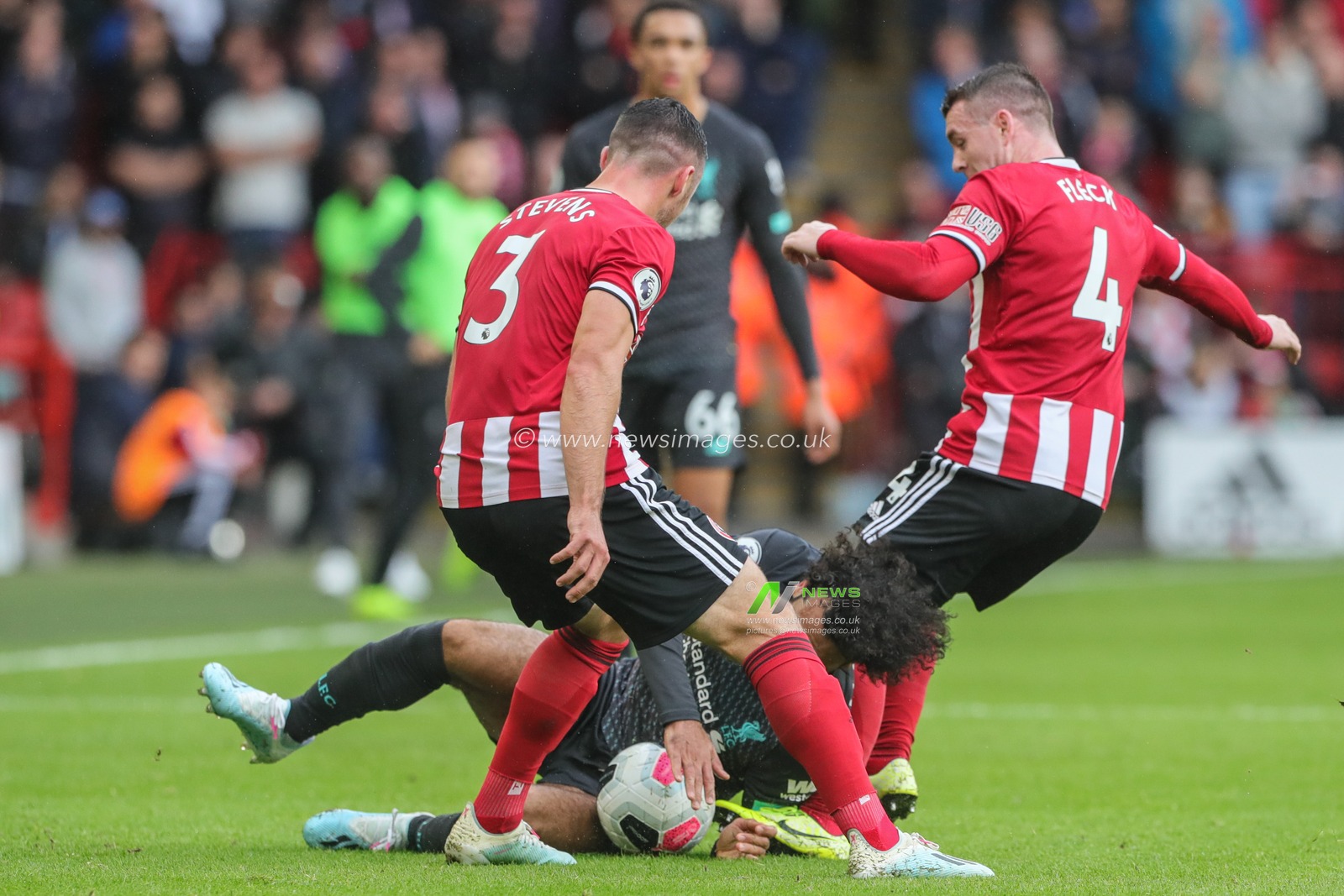 28th September 2019, Bramall Lane, Sheffield, England; Premier League, Sheffield United v Liverpool : Mohamed Salah (11) of Liverpool is fouled by John Fleck (4) of Sheffield United and Enda Stevens (3) of Sheffield United 

Credit: Mark Cosgrove/News Images