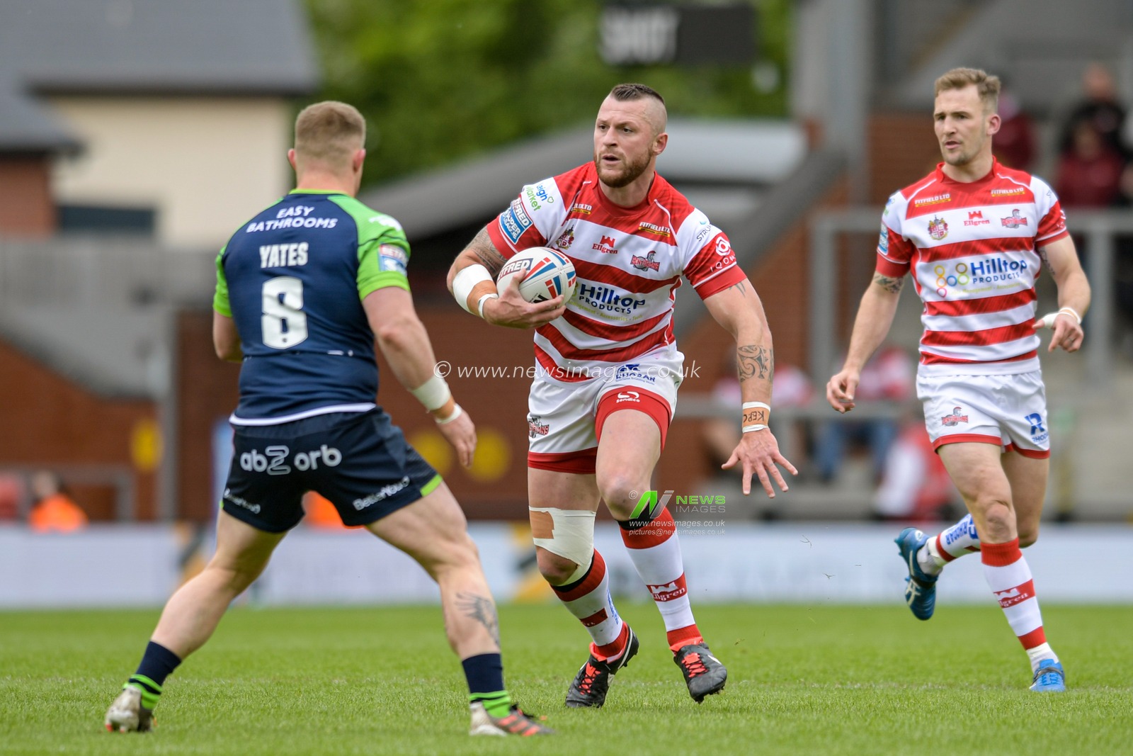 Adam Sidlow (20) of Leigh Centurions looks for a way past Luke Yates (8) of Huddersfield Giants