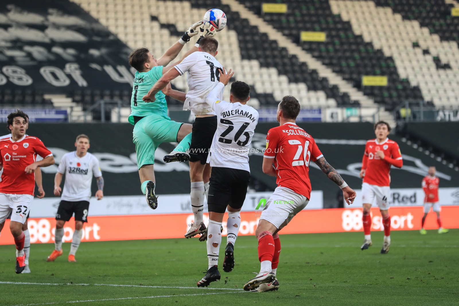 Jack Walton #1 of Barnsley clears the ball as Matthew Clarke #16 of Derby County fouls him