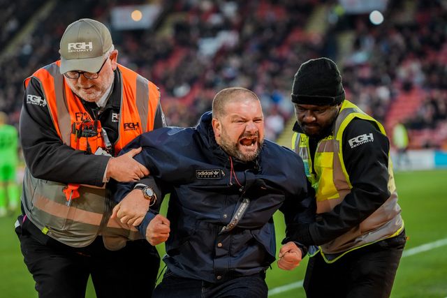 A pitch invader celebrates Yuki Ohashi of Blackburn Rovers scoring to make it 0-2 as security tries to remove him from the pitch during the Sky Bet Championship match Sheffield United vs Blackburn Rovers at Bramall Lane, Sheffield, United Kingdom on 22 April 2026

(Photo by Maynard Manyowa/News Images)