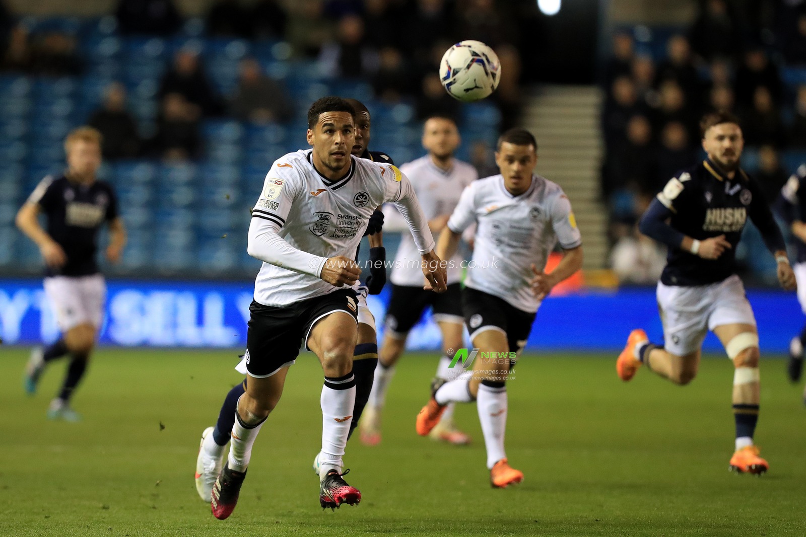 Ryan Manning #3 of Swansea City chases the ball with Benik Afobe #23 of Millwall in pursuit.