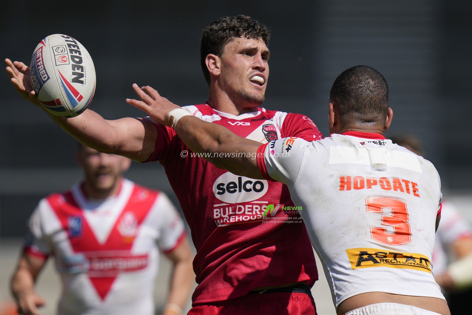 Sam Stone #12 of Salford Red Devils looks to off load the ball under pressure from Will Hopoate #3 of St. Helens during the Betfred Super League Round 12 match St Helens vs Salford Red Devils at Totally Wicked Stadium, St Helens, United Kingdom, 13th May 2023

(Photo by Steve Flynn/News Images)