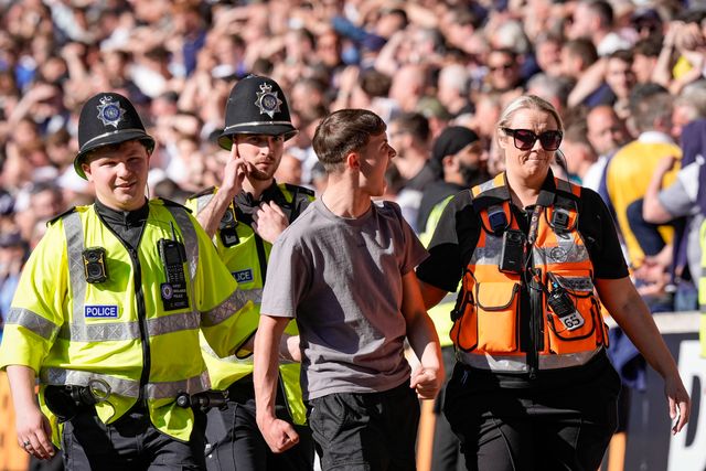 A fan is escorted and ejected from the ground by the police  for attempting to  invade the field of playduring the Premier League match Wolverhampton Wanderers vs Tottenham Hotspur at Molineux, Wolverhampton, United Kingdom on 25 April 2026

(Photo by Maynard Manyowa/News Images)