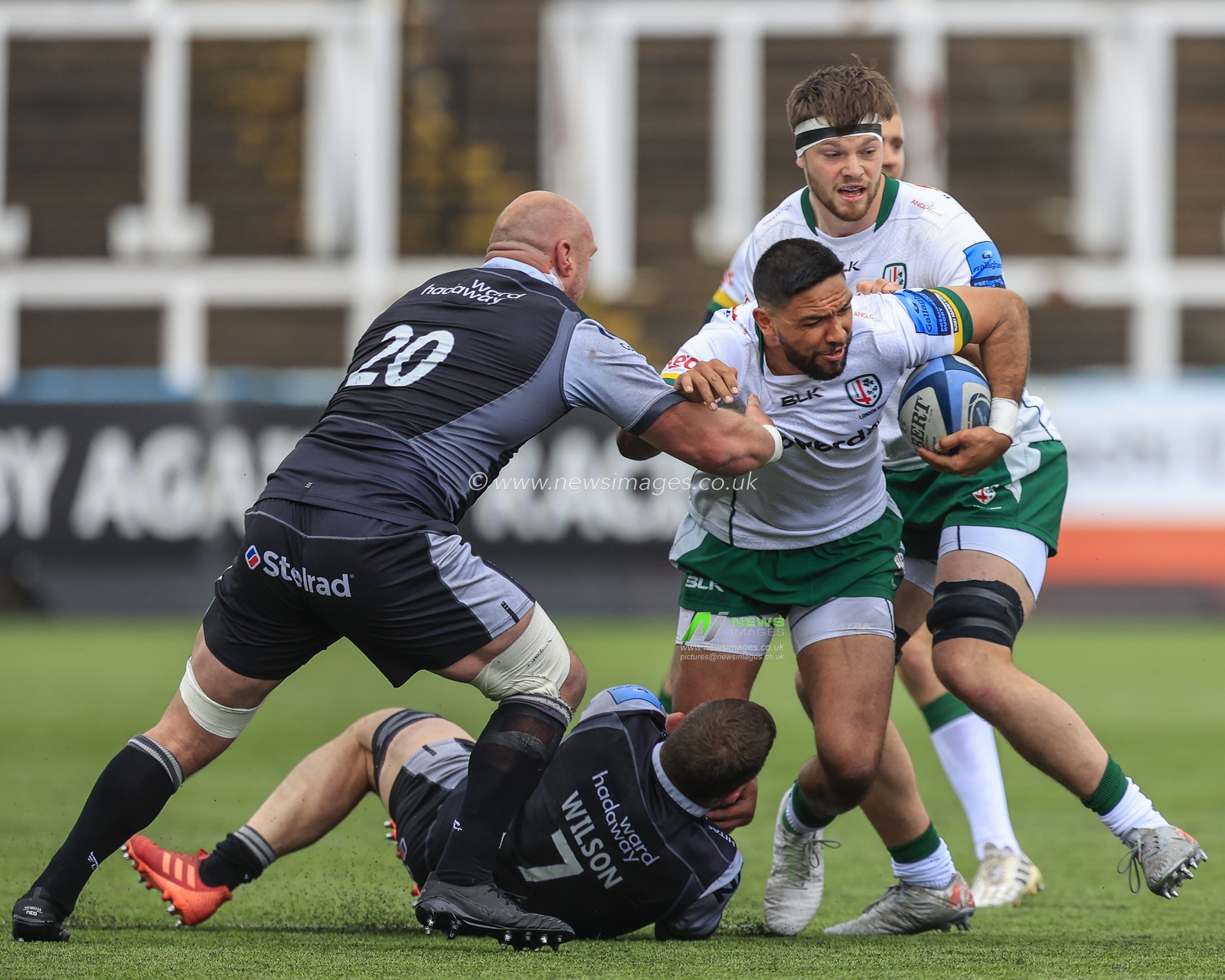 Curtis Rona of London Irish is tackled by Mark Wilson of Newcastle Falcons and Carl Fearns of Newcastle Falcons