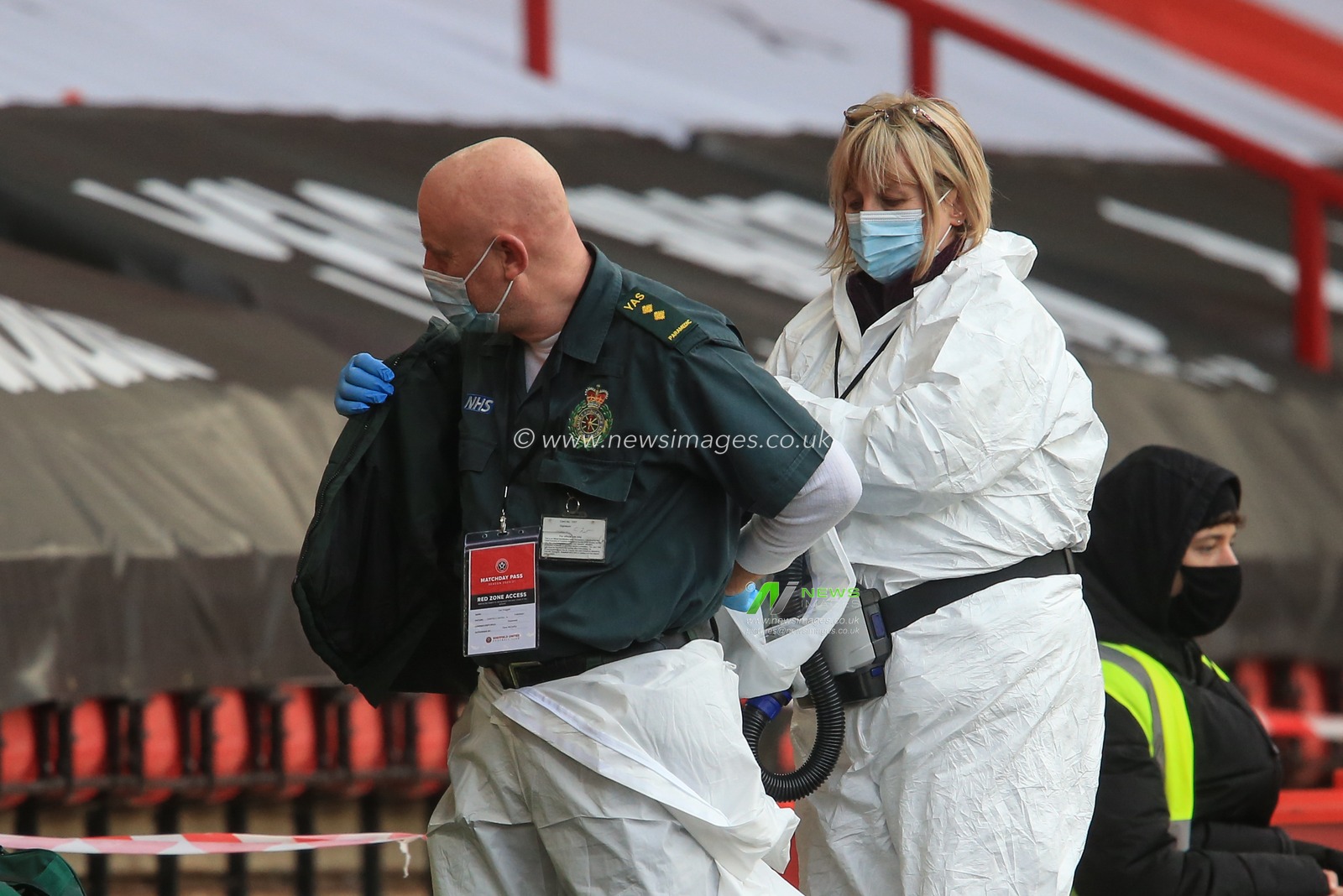 NHS game staff prepare for the game as they dress in white protective suites as part of the Covid 19 protocol in the red zone
