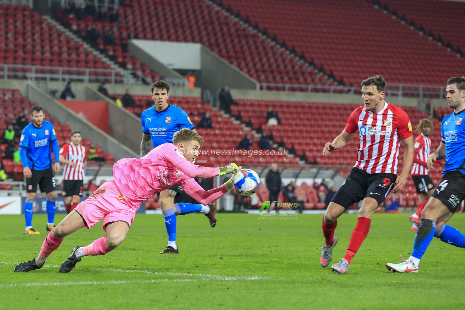 Connal Trueman #1 of Swindon Town dives towards the ball to prevent Charlie Wyke #9 of Sunderland gaining possession