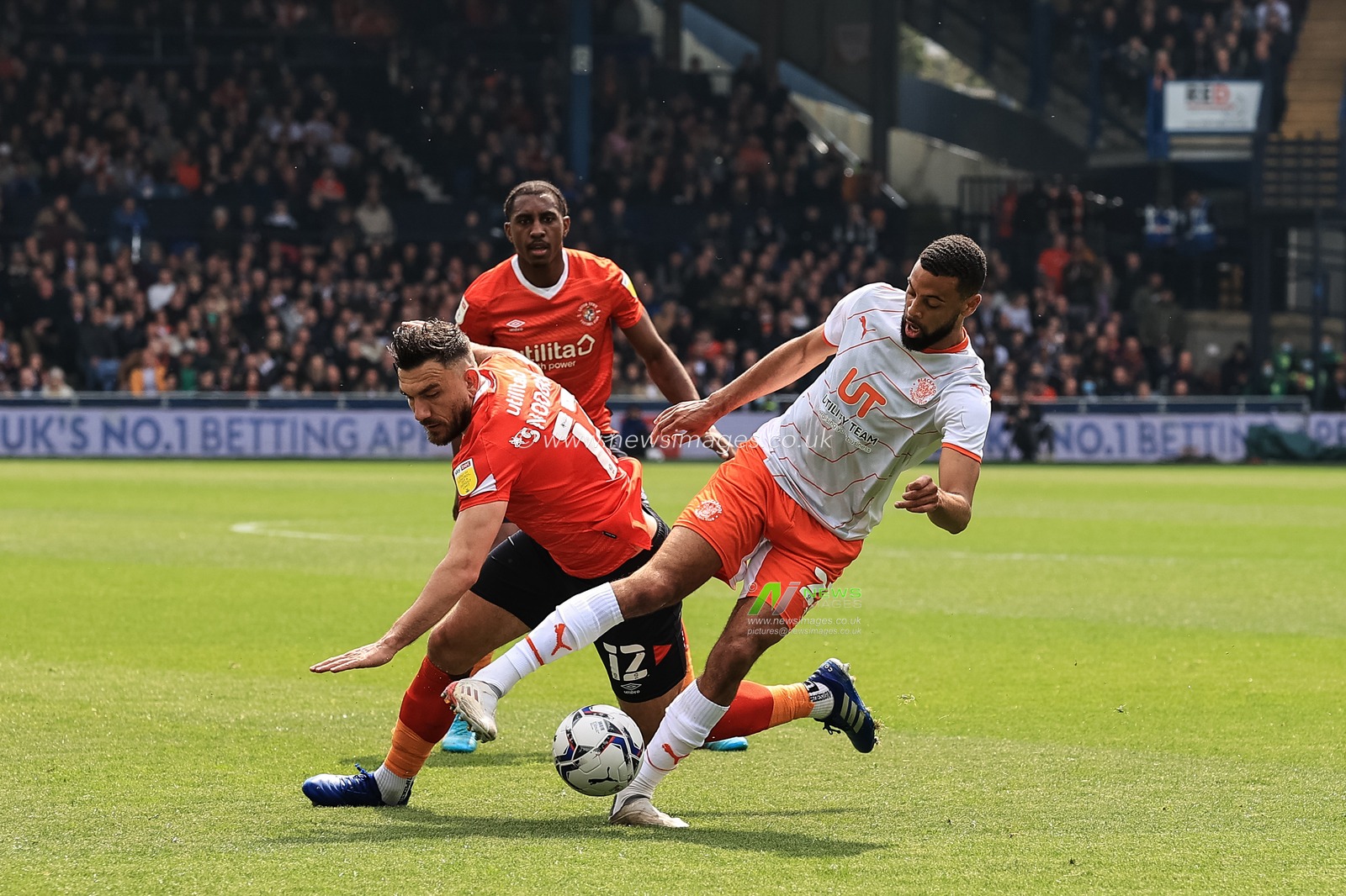 CJ Hamilton #22 of Blackpool wins the ball from Robert Snodgrass #12 of Luton Town