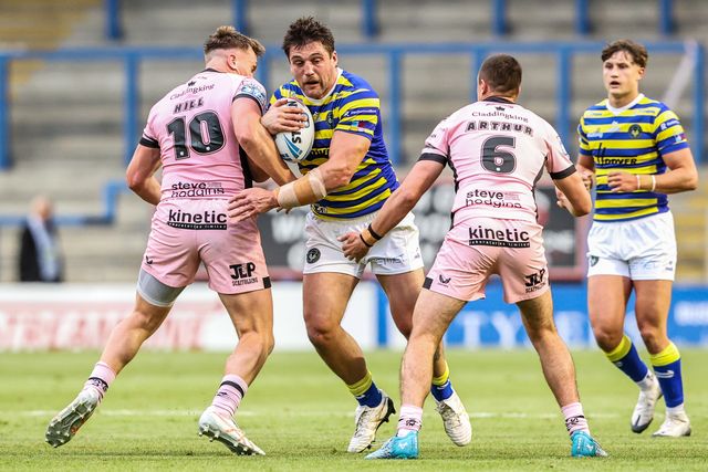 Liam Byrne of Warrington Wolves is tackled by Harvie Hill of Hull FC and Jake Arthur of Hull FC during the Betfred Super League round 13 match Warrington Wolves vs Hull FC at The Halliwell Jones Stadium, Warrington, United Kingdom on 05 June 2026

(Photo by Alfie Cosgrove/News Images)