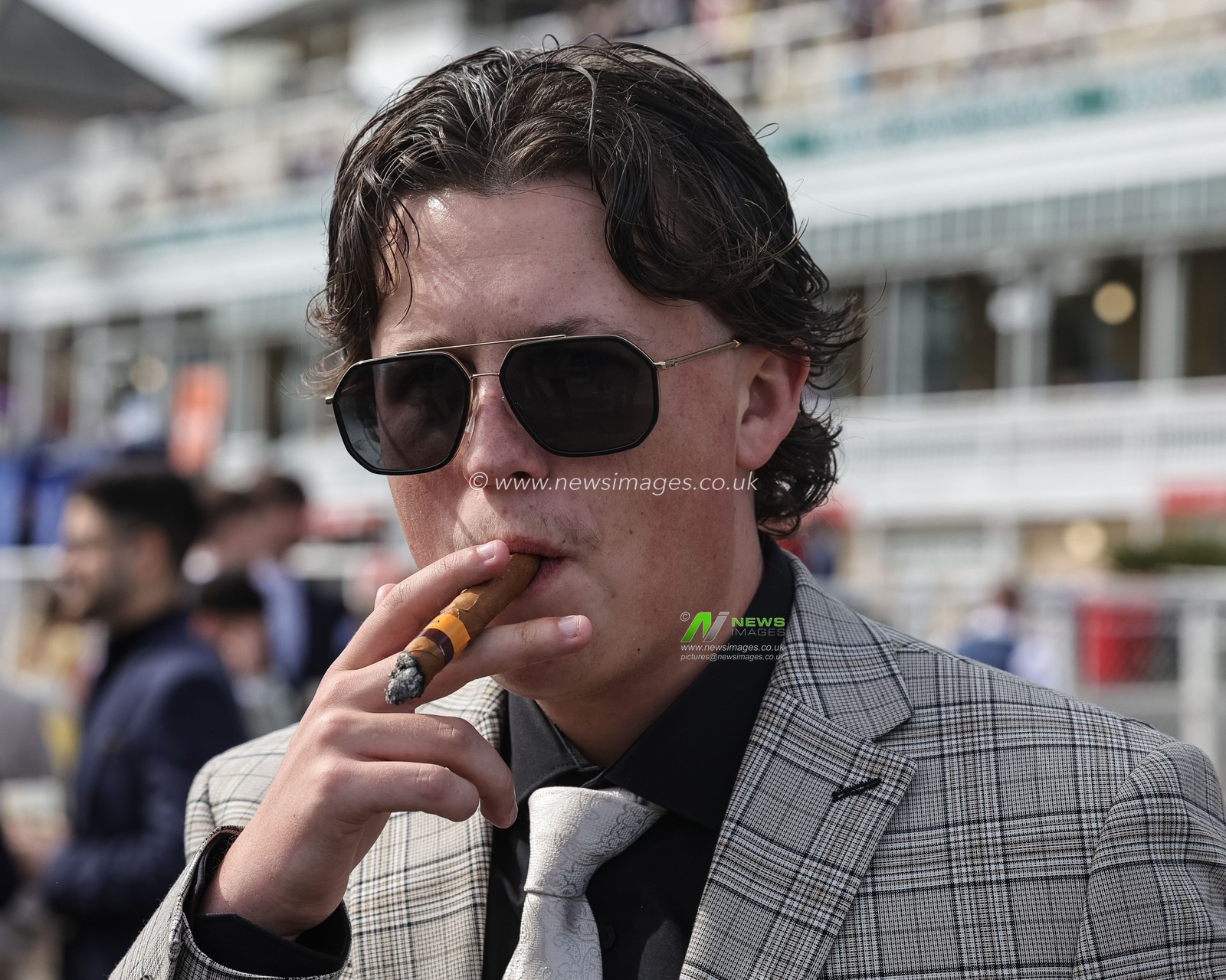 A racegoer taking in a cigar during the 2026 Randox Grand National Ladies Day at Aintree Racecourse, Aintree, United Kingdom on 10 April 2026

(Photo by Mark Cosgrove/News Images)