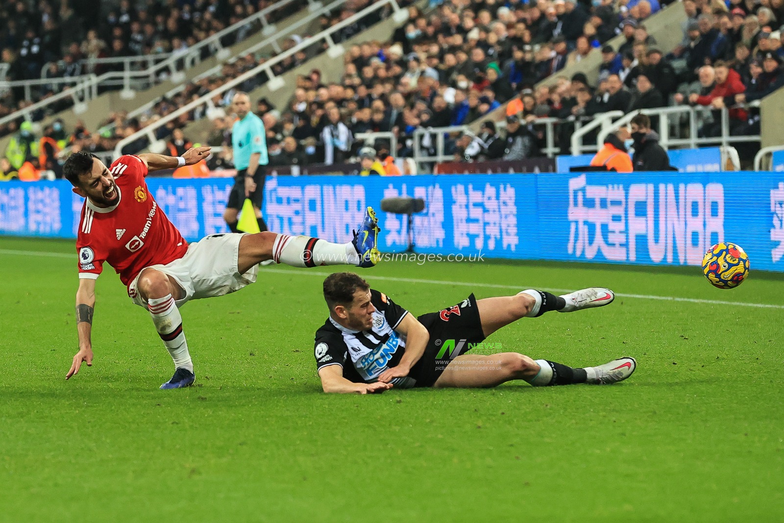 Ryan Fraser #21 of Newcastle United wins the ball from Bruno Fernandes #18 of Manchester United