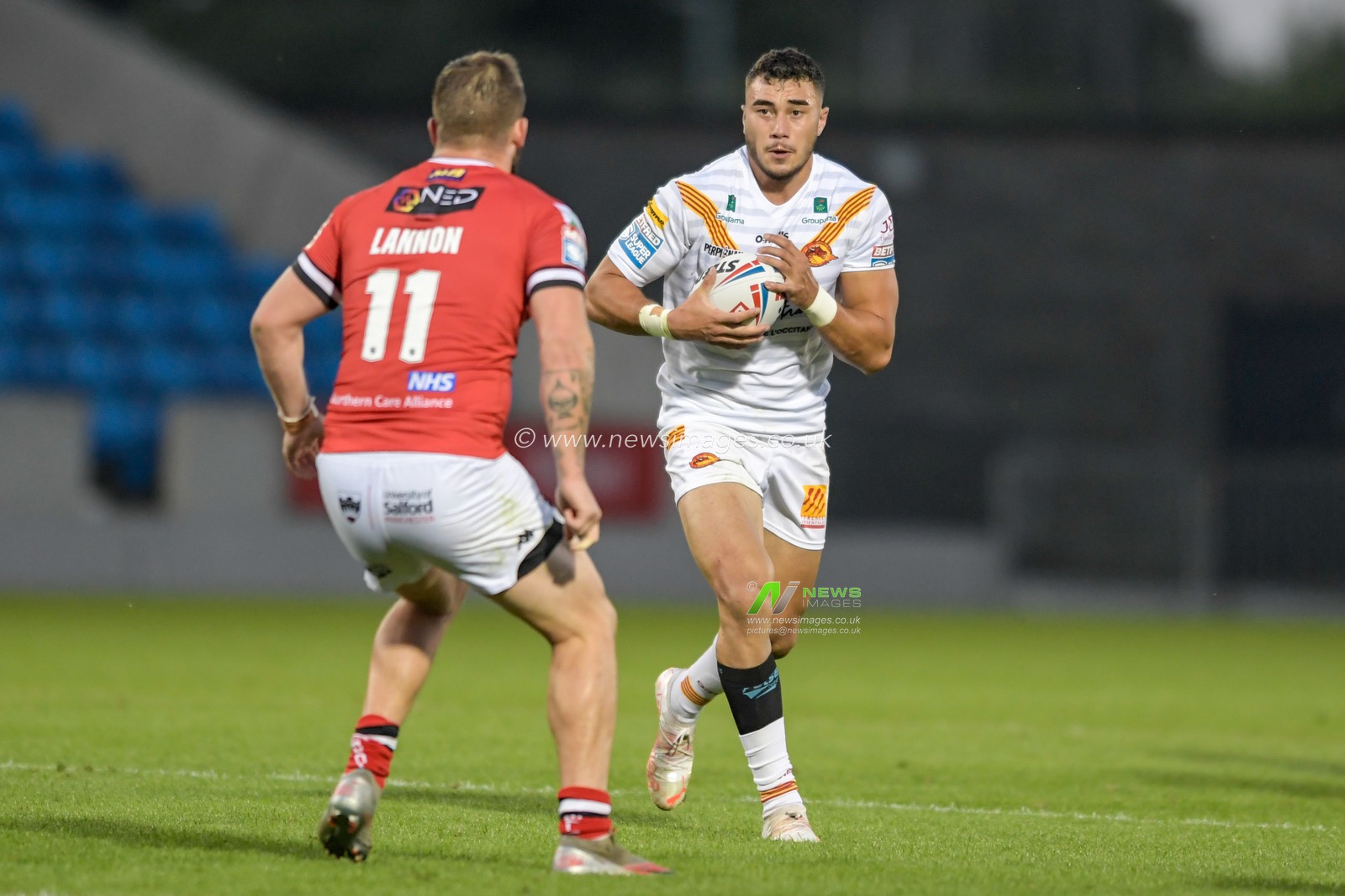 Joe Chan (27) of Catalans Dragons looks for a way past Ryan Lannon (11) of Salford Red Devils
