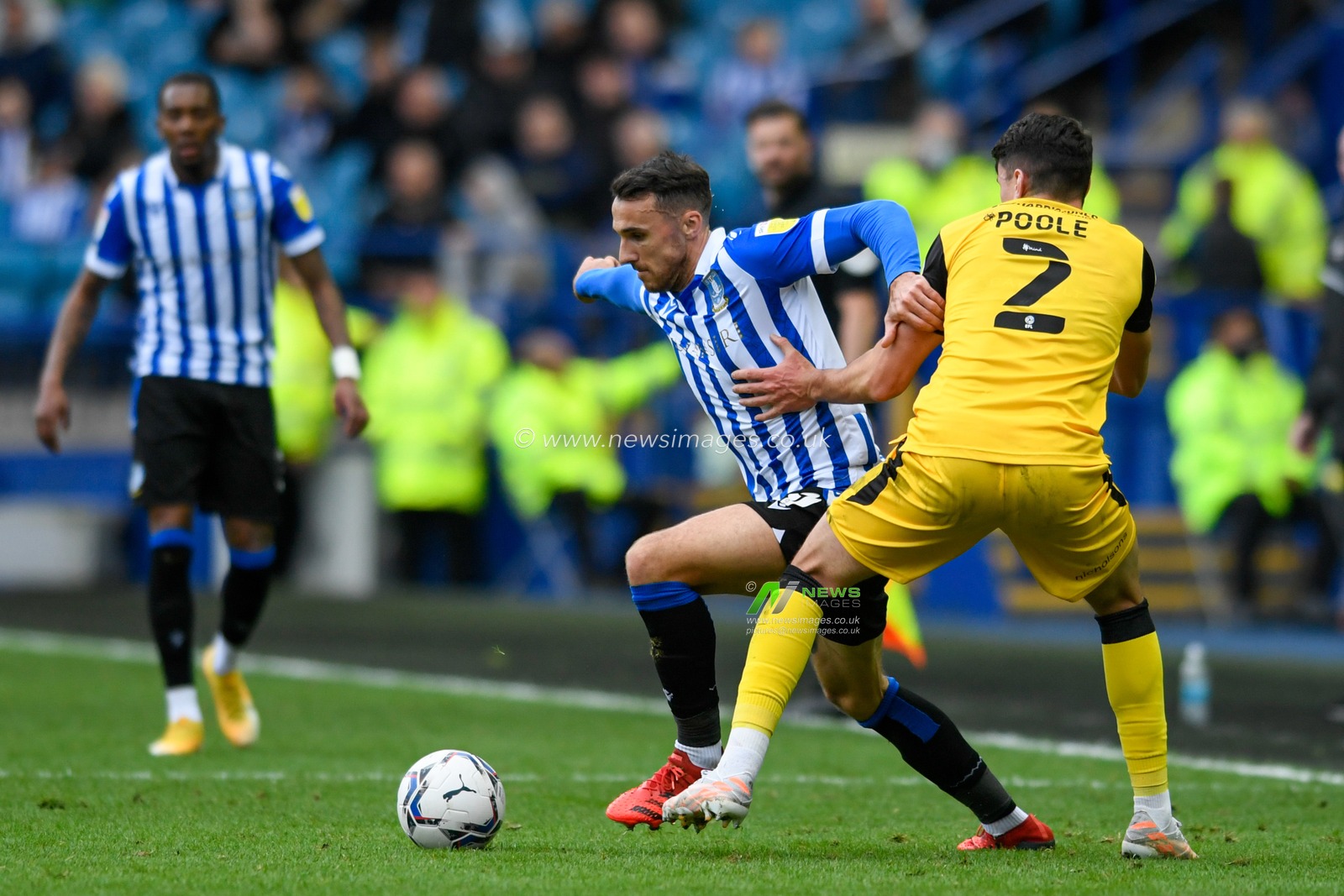 Lee Gregory #9 of Sheffield Wednesday runs past Regan Poole #2 of Lincoln City