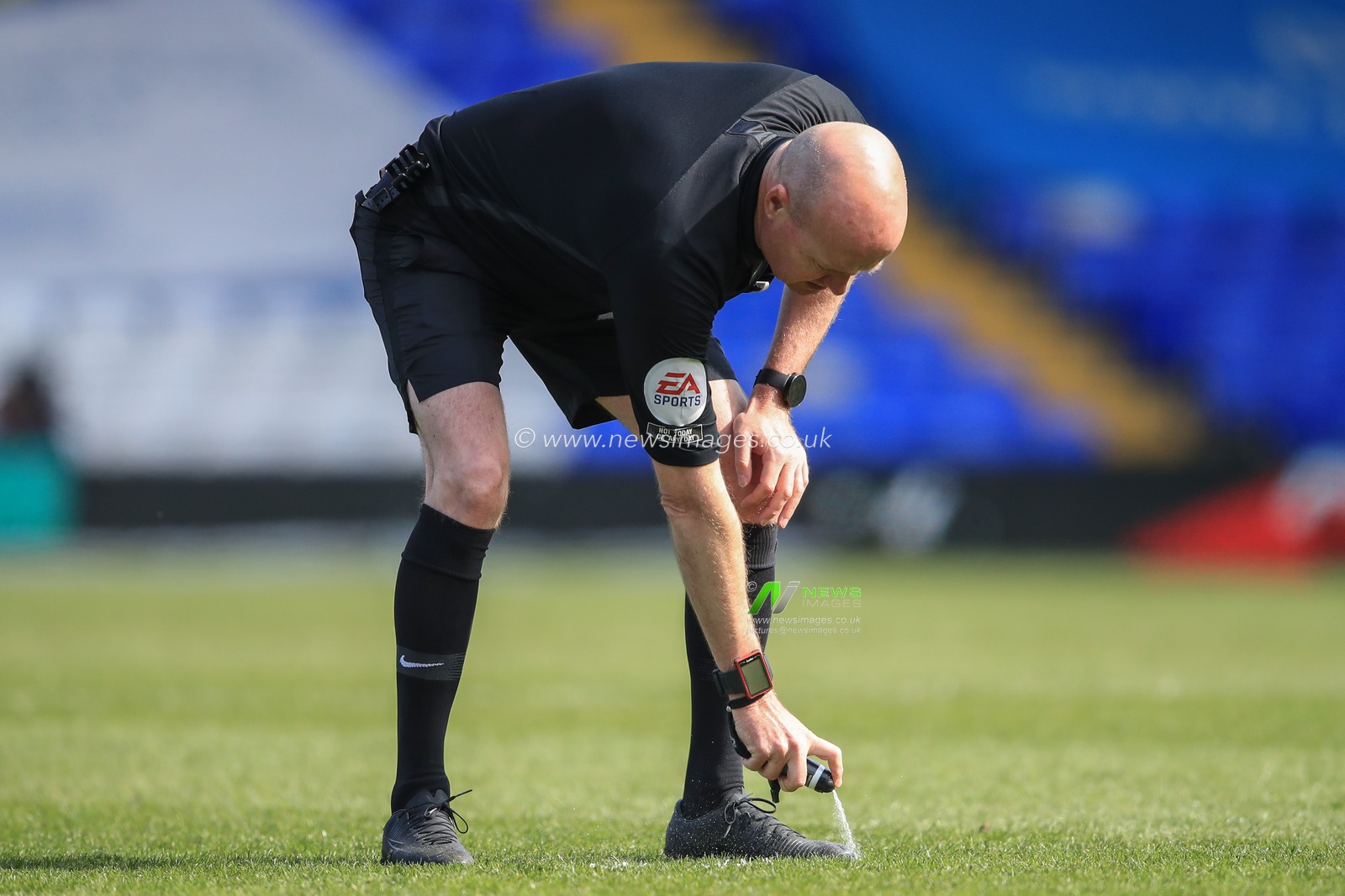 Referee Lee Mason marks the spot for a free-kick with his foam spray