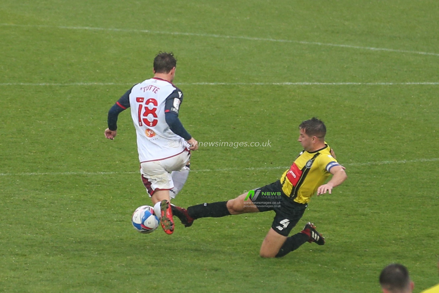 Josh Falkingham (4) of Harrogate Town is given a yellow after a bad tackle on Andrew Tutte (18) of Bolton Wanderers