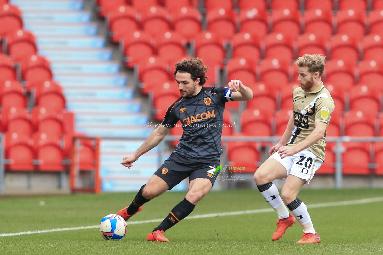 Lewis Coyle #2 of Hull City passes the ball dow field as Josh Sims #20 of Doncaster Rovers pressures