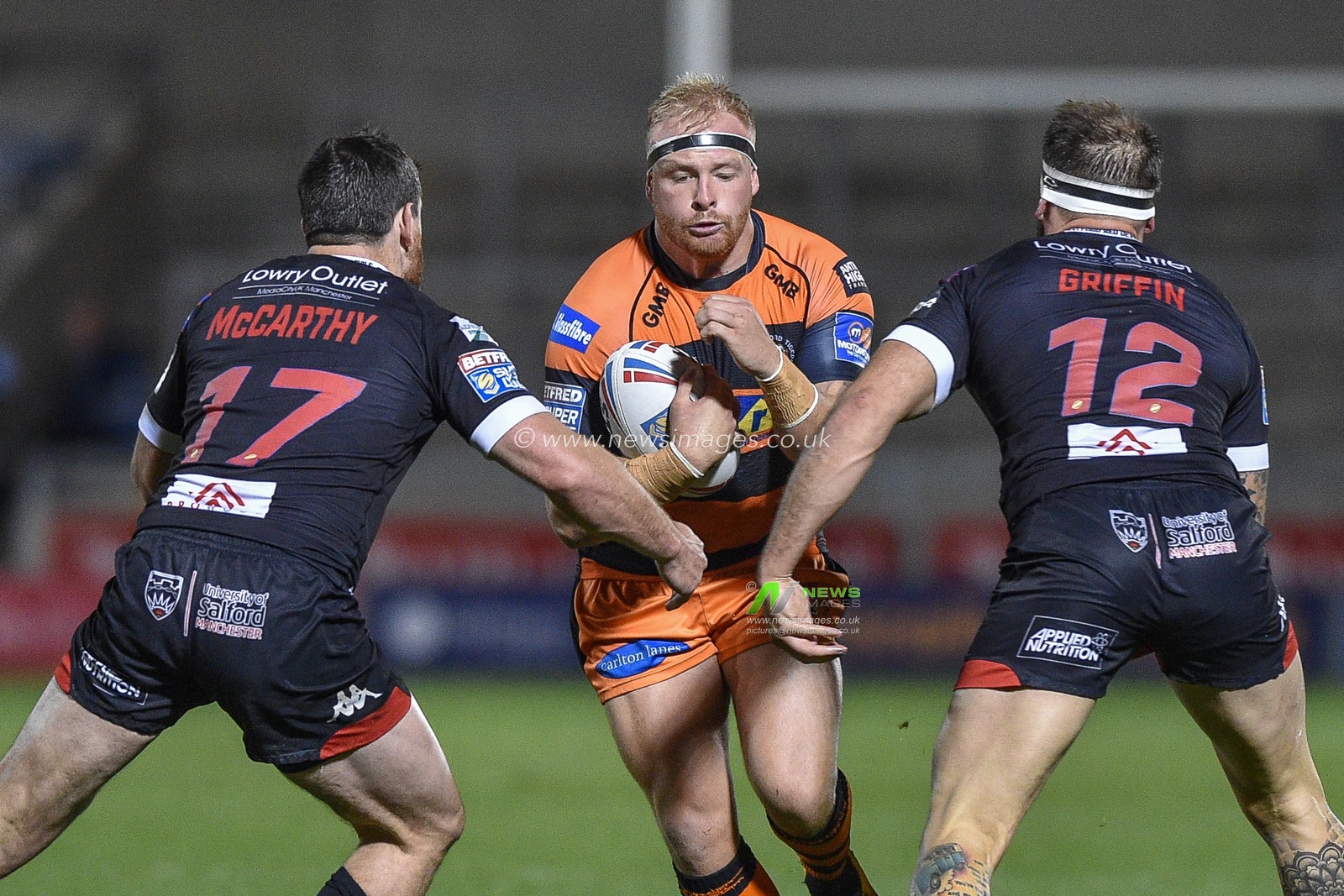 26th September 2019 ,  AJ Bell Stadium, Salford, England;  Betfred Super League Rugby, Round Eliminator 2, Salford Red Devils vs Castleford Tigers ; Castleford Tigers Oliver Holmes takes the ball to Salford Red Devils Tyrone McCarthy and George Griffin.

Credit: Dean Williams/News Images