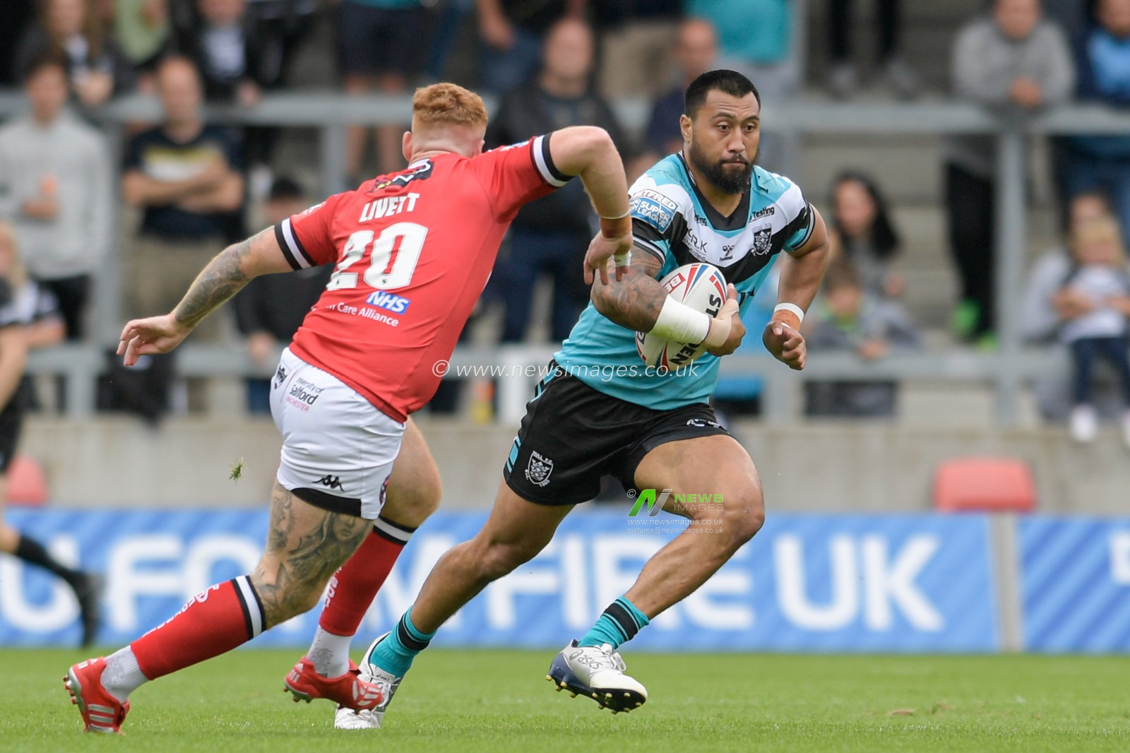 Ligi Sao (13) of Hull FC looks for a way past Harvey Livett (20) of Salford Red Devils