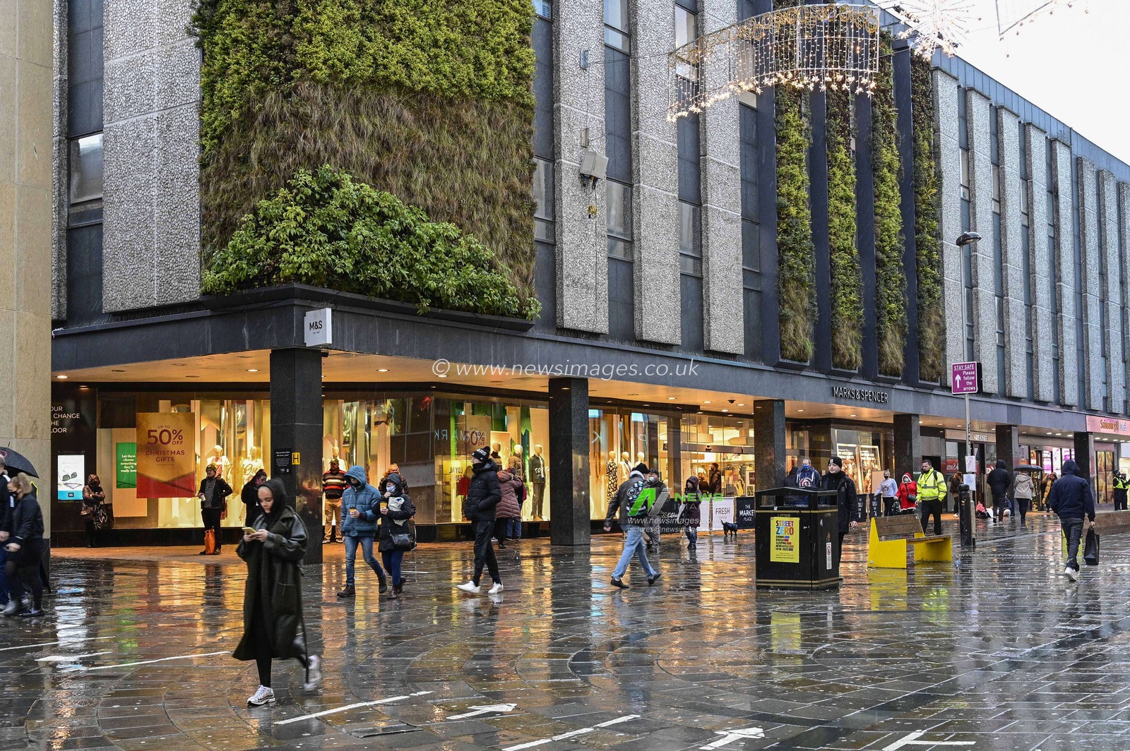 A wet Northumberland Street in Newcastle upon Tyne on Christmas Eve as shoppers venture out in the sleet