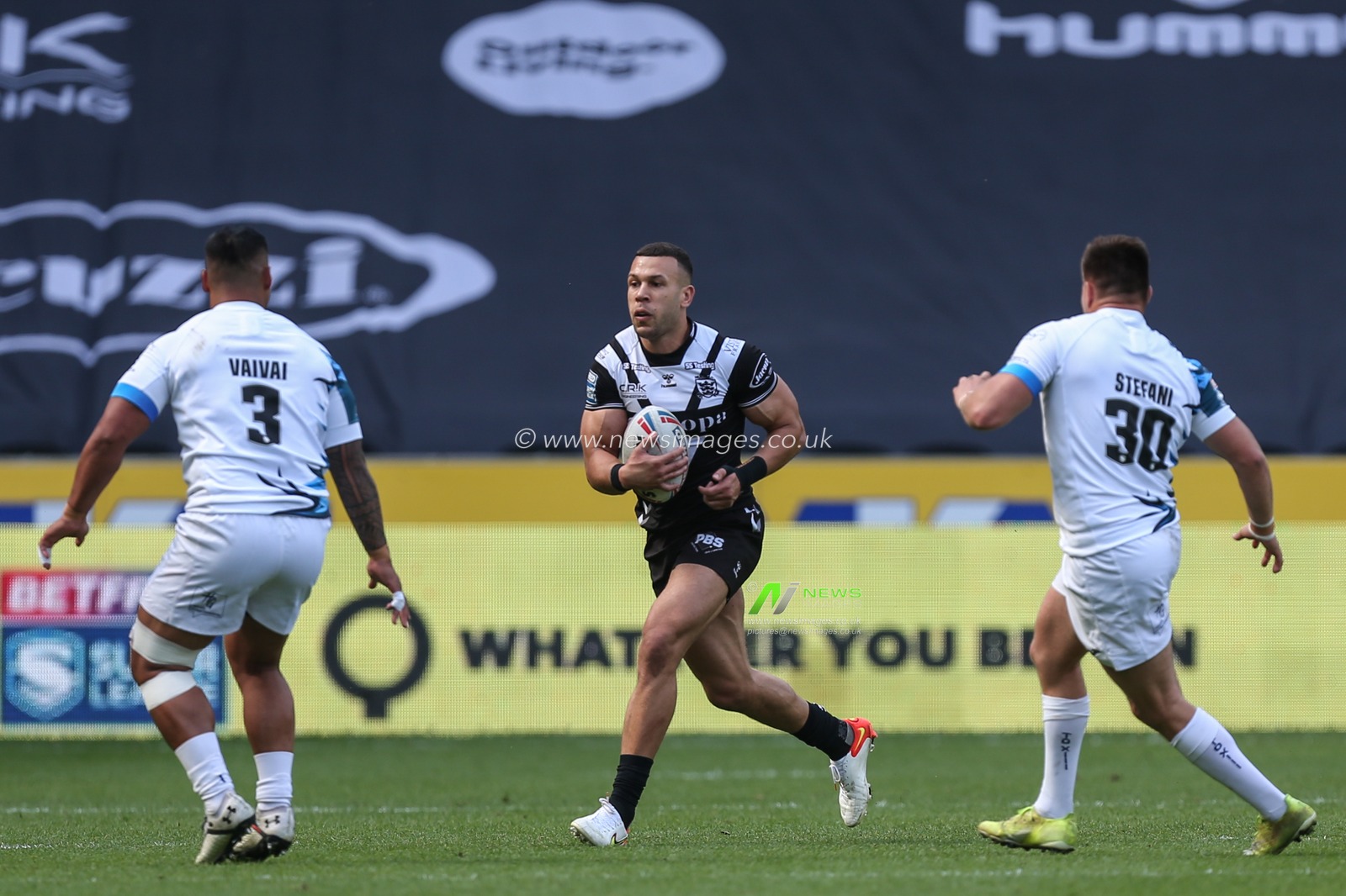 Carlos Tuimavave #3 of Hull FC runs at  Junior Vaivai #3 and Maxime Stefani #30 of Toulouse Olympique