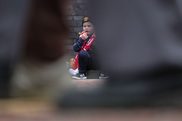 A young Manchester United fans sits in the road curb as he grabs a bite to eat during the Premier League match Manchester United vs Crystal Palace at Old Trafford, Manchester, United Kingdom on 01 March 2026

(Photo by Mark Cosgrove/News Images)