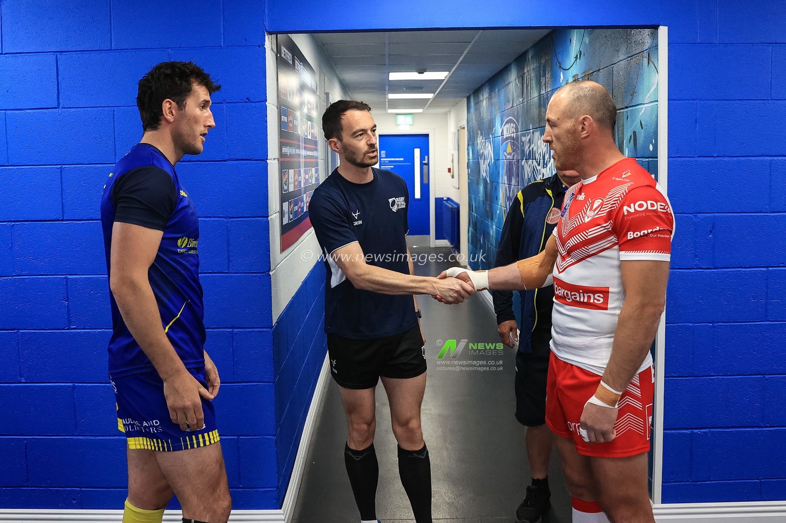 Referee James Child  shakes hands with James Roby #9 of St Helens