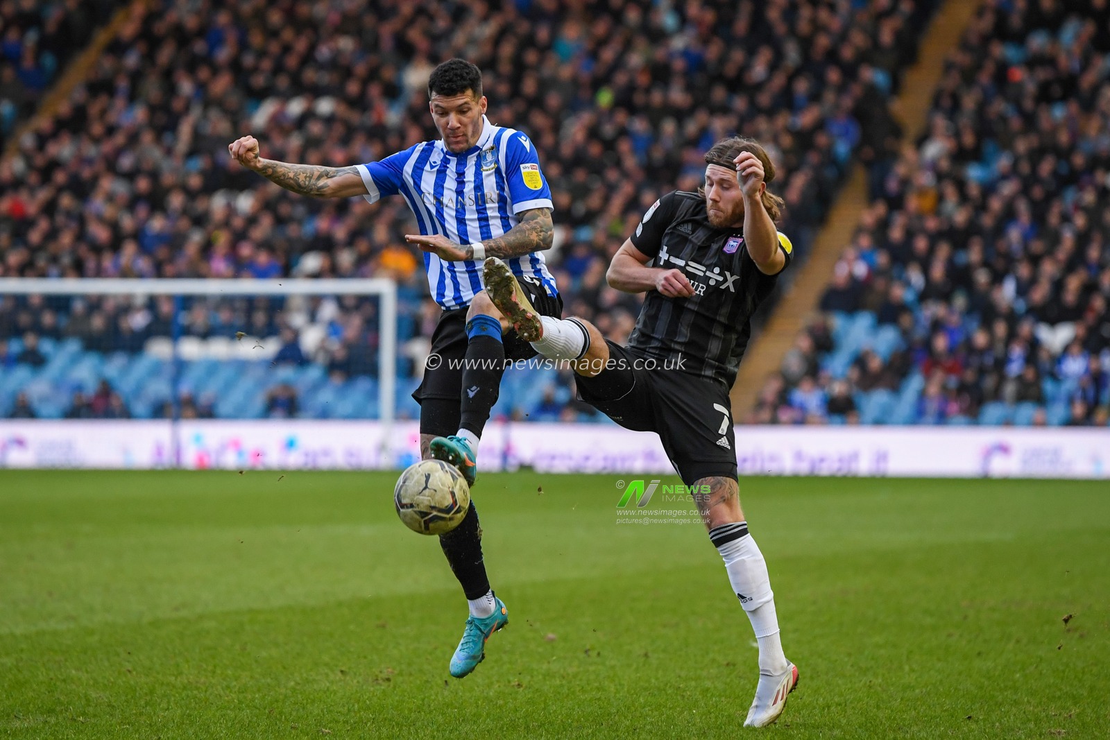 Marvin Johnson #18 of Sheffield Wednesday competes for the ball with Wes Burns #7 of Ipswich Town