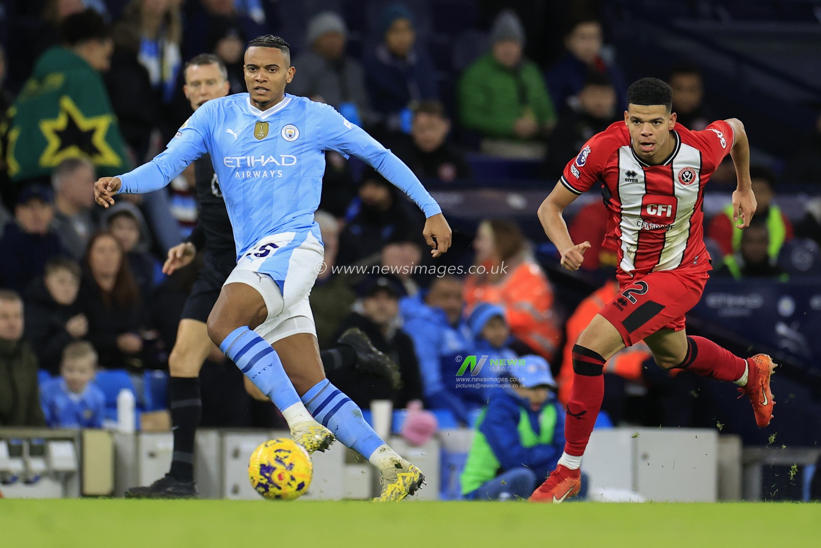 Manuel Akanji #25 of Manchester City passes the ball under pressure from William Osula #32 of Sheffield United during the Premier League match Manchester City vs Sheffield United at Etihad Stadium, Manchester, United Kingdom, 30th December 2023

(Photo by Conor Molloy/News Images)