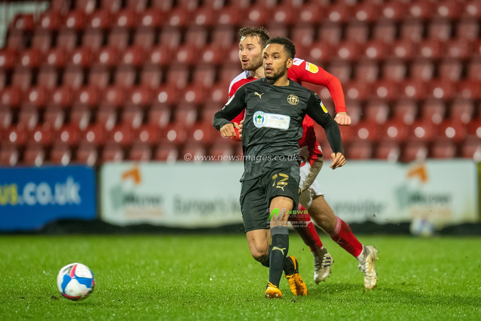 Funso Ojo #12 of Wigan Athletic passes the ball to a team mate
