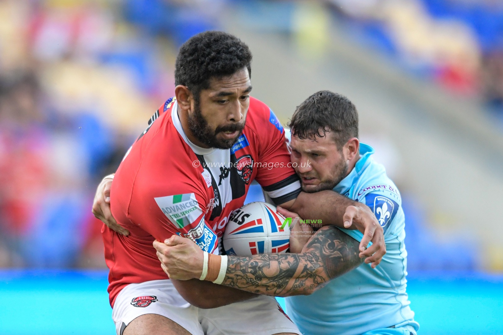 Sebastine Ikahihifo (10) of Salford Red Devils is tackled by Jay Pitts (14) of Wakefield Trinity