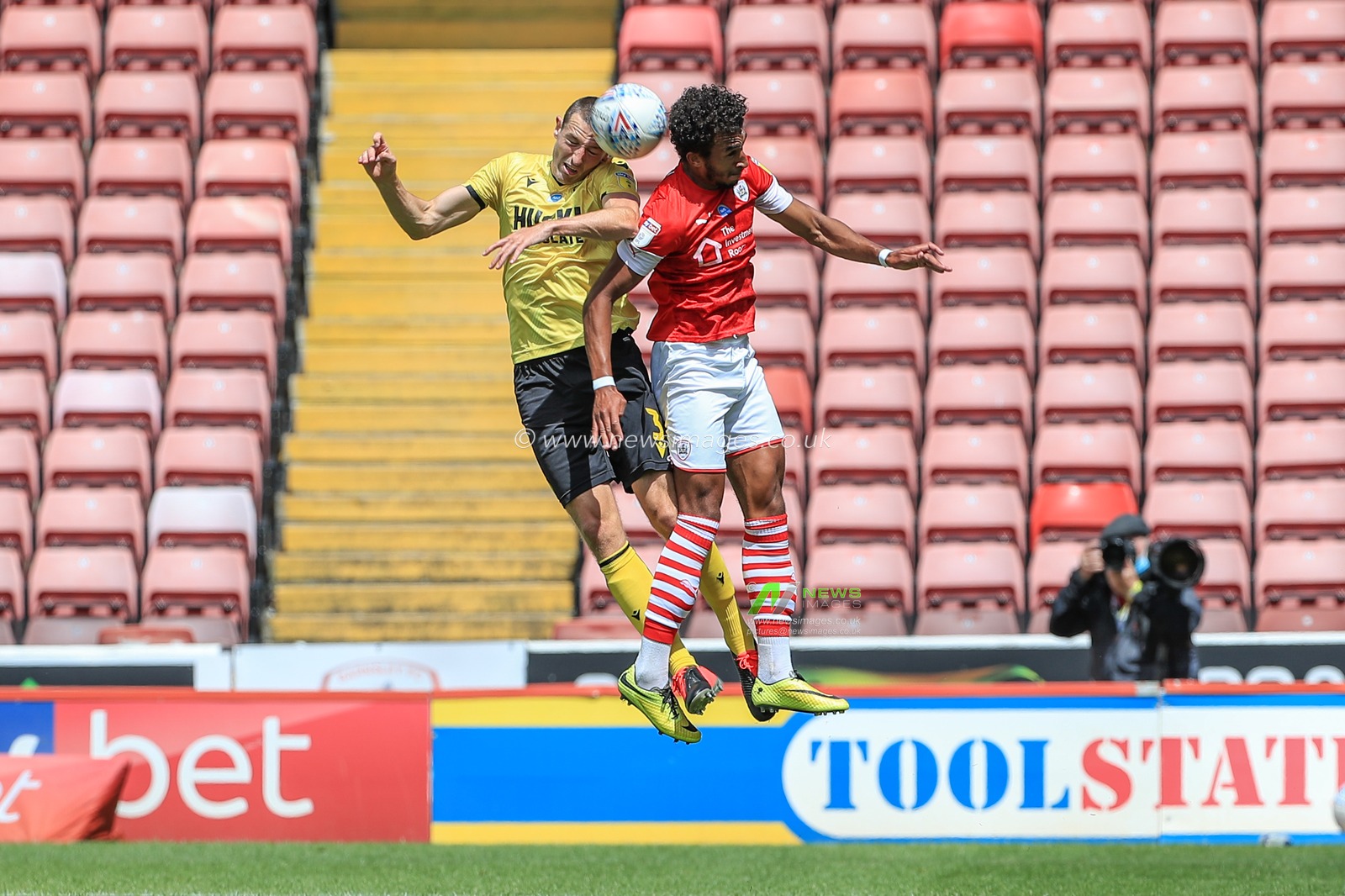 Romal Palmer (41) of Barnsley and Murray Wallace (3) of Millwall dual for the ball