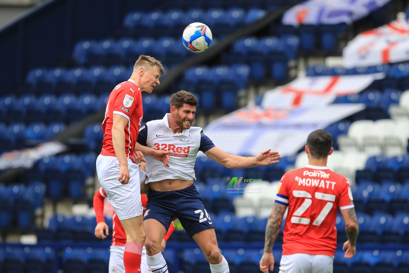 Mads Juel Andersen #6 of Barnsley wins the high-ball with Ched Evans #26 of Preston North End