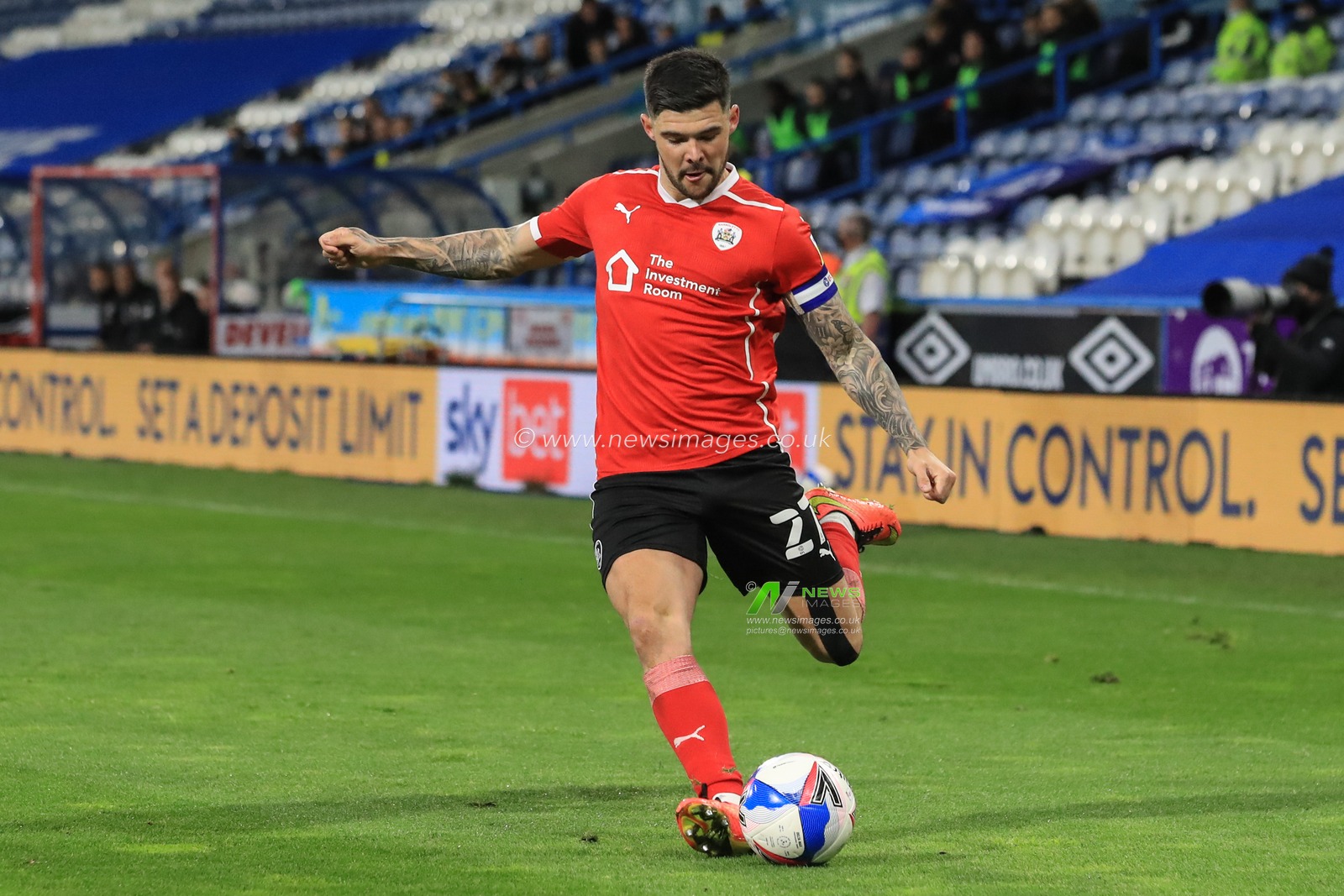 Alex Mowatt #27 of Barnsley crosses the ball into Huddersfieldâ€™s area