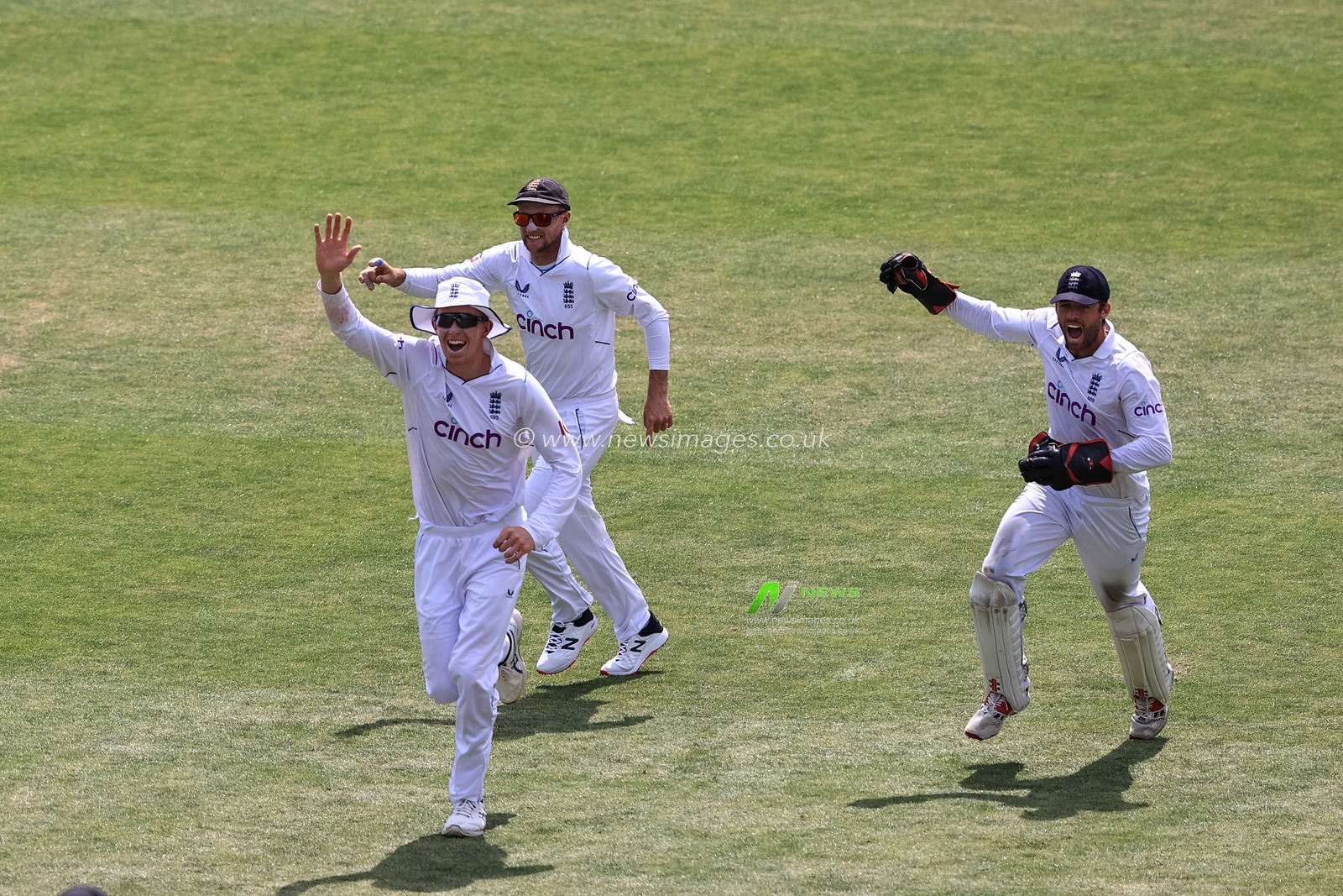 Zak Crawley of England (L) Joe Root of England (C) and Ben Foakes of England (R) celebrate the wicket of Kane Williamson of New Zealand after Foakes catches his