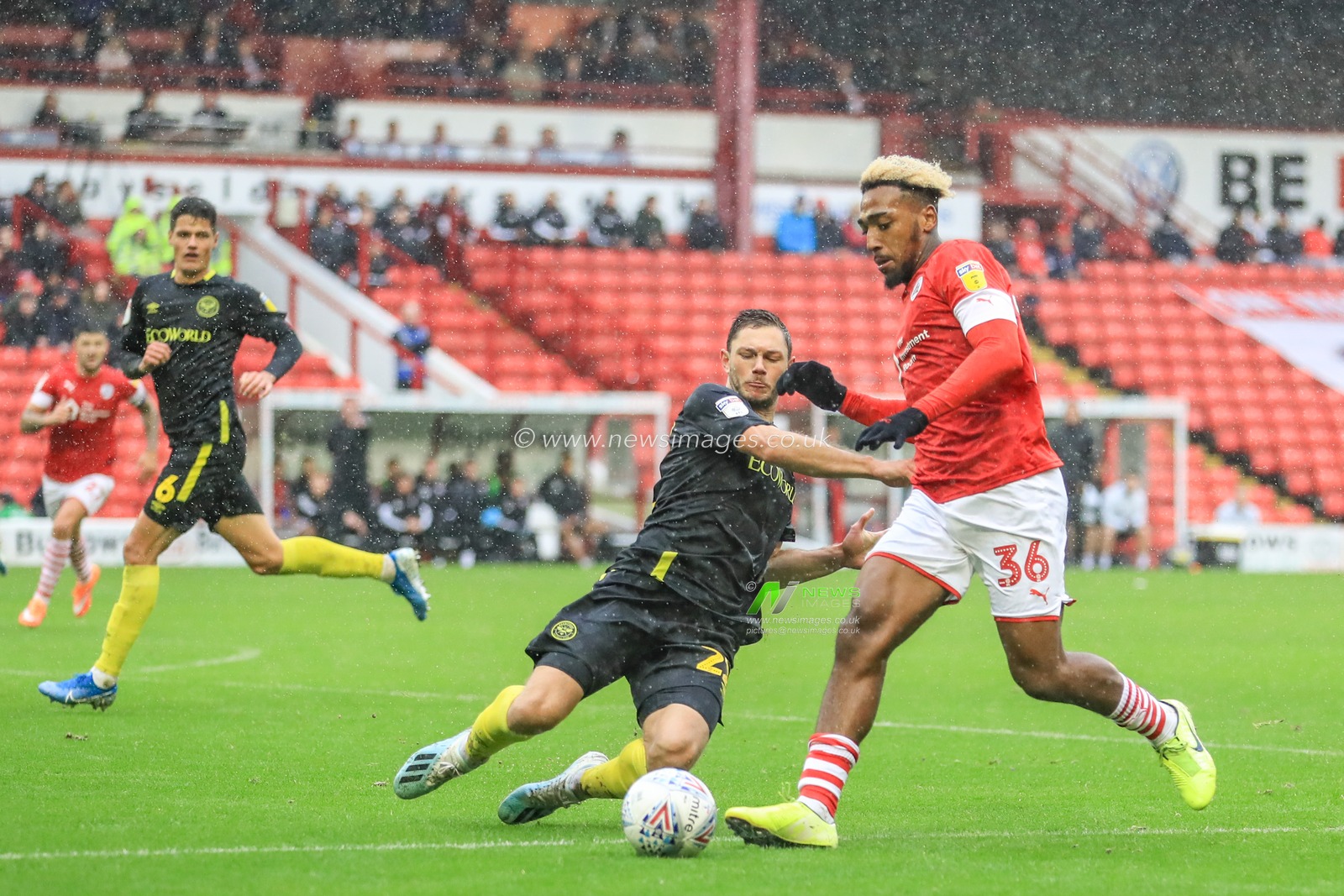 29th September 2019, Oakwell, Barnsley, England; Sky Bet Championship, Barnsley v Brentford : Mallik Wilks (36) of Barnsley is tackled by Henrik Dalsgaard (22) of Brentford 

Credit: Mark Cosgrove/News Images