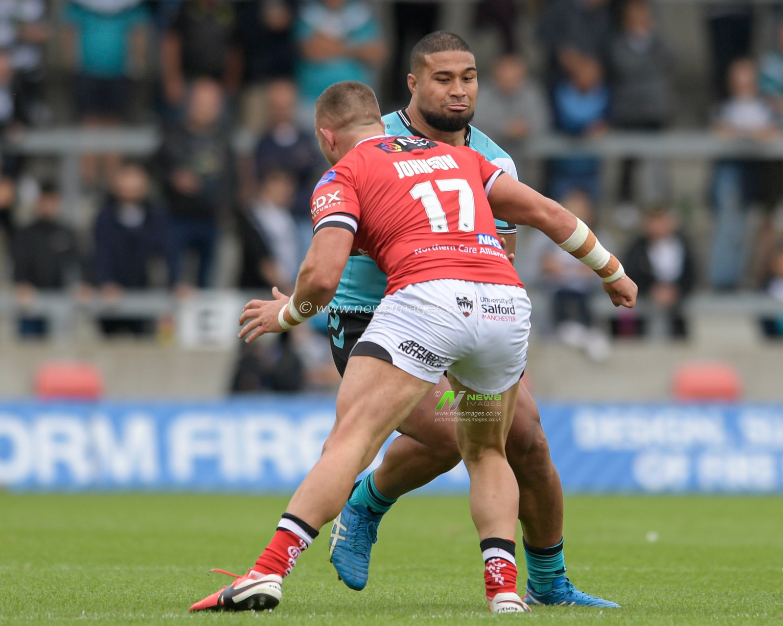 Chris Satae (10) of Hull FC is tackled by Josh Johnson (17) of Salford Red Devils