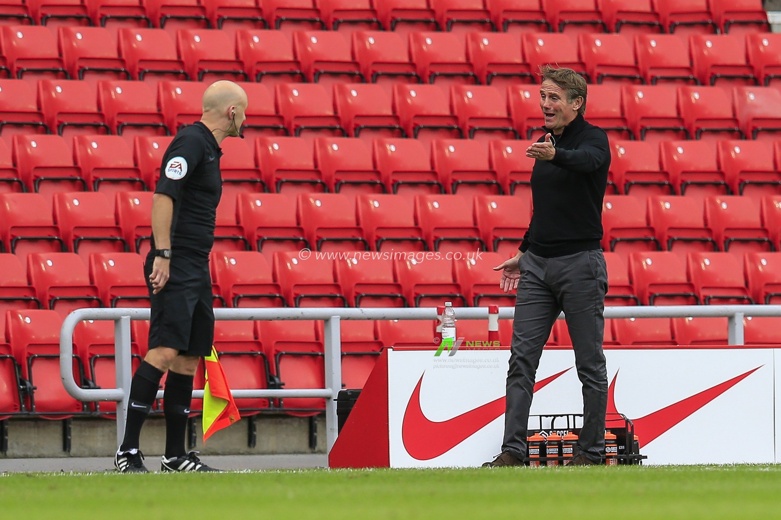 Phil Parkinson, manager of Sunderland in discussion with the referee's assistant