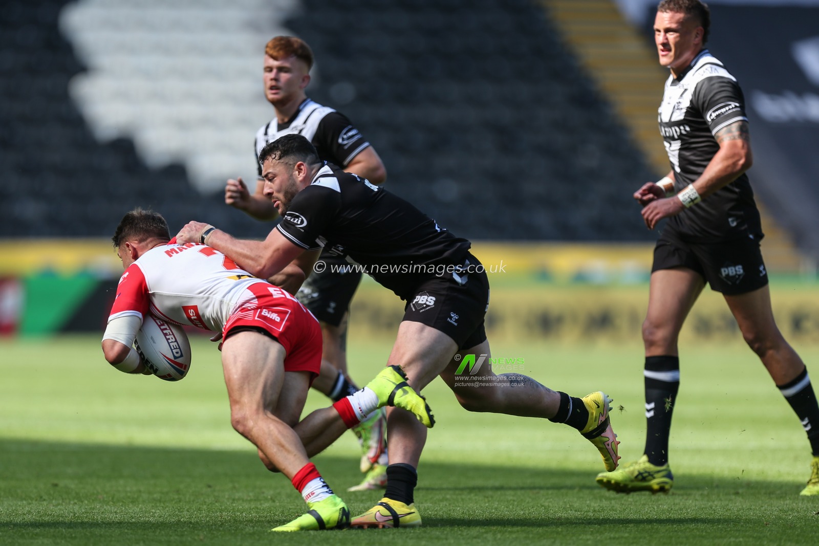 Jake Connor #1 of Hull FC grabs hold of Tommy Makinson #2 of St Helens
