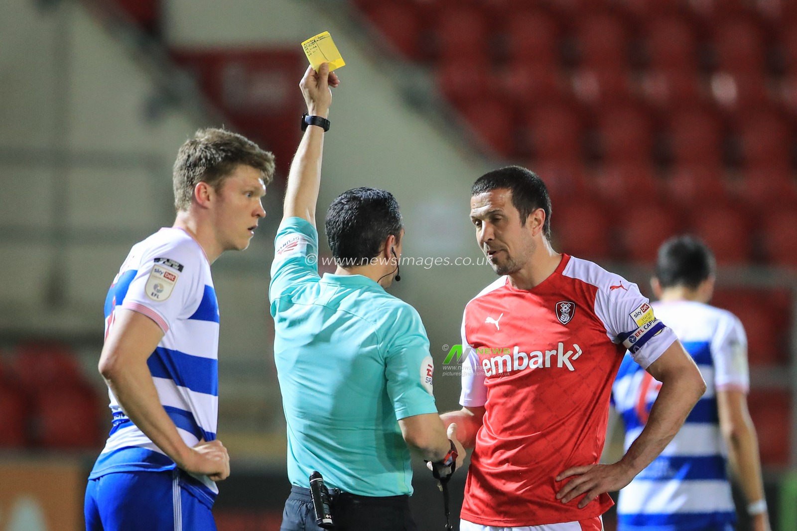 Referee Dean Whitestone gives Richard Wood #6 of Rotherham United a yellow card for the late challenge on Seny Dieng #13 of Queens Park Rangers